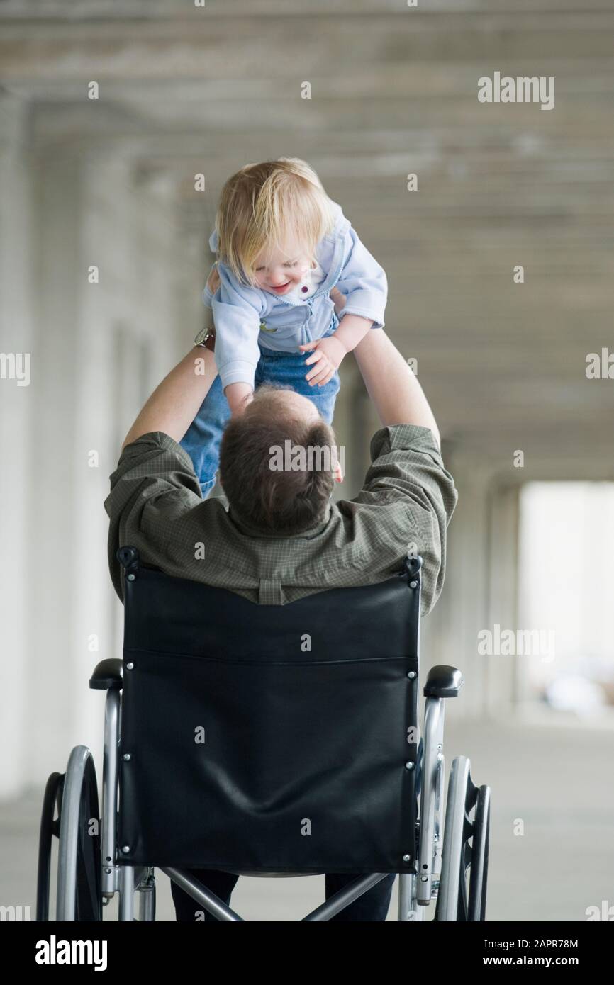 L'homme en chaise roulante à jouer avec bébé Photo Stock - Alamy