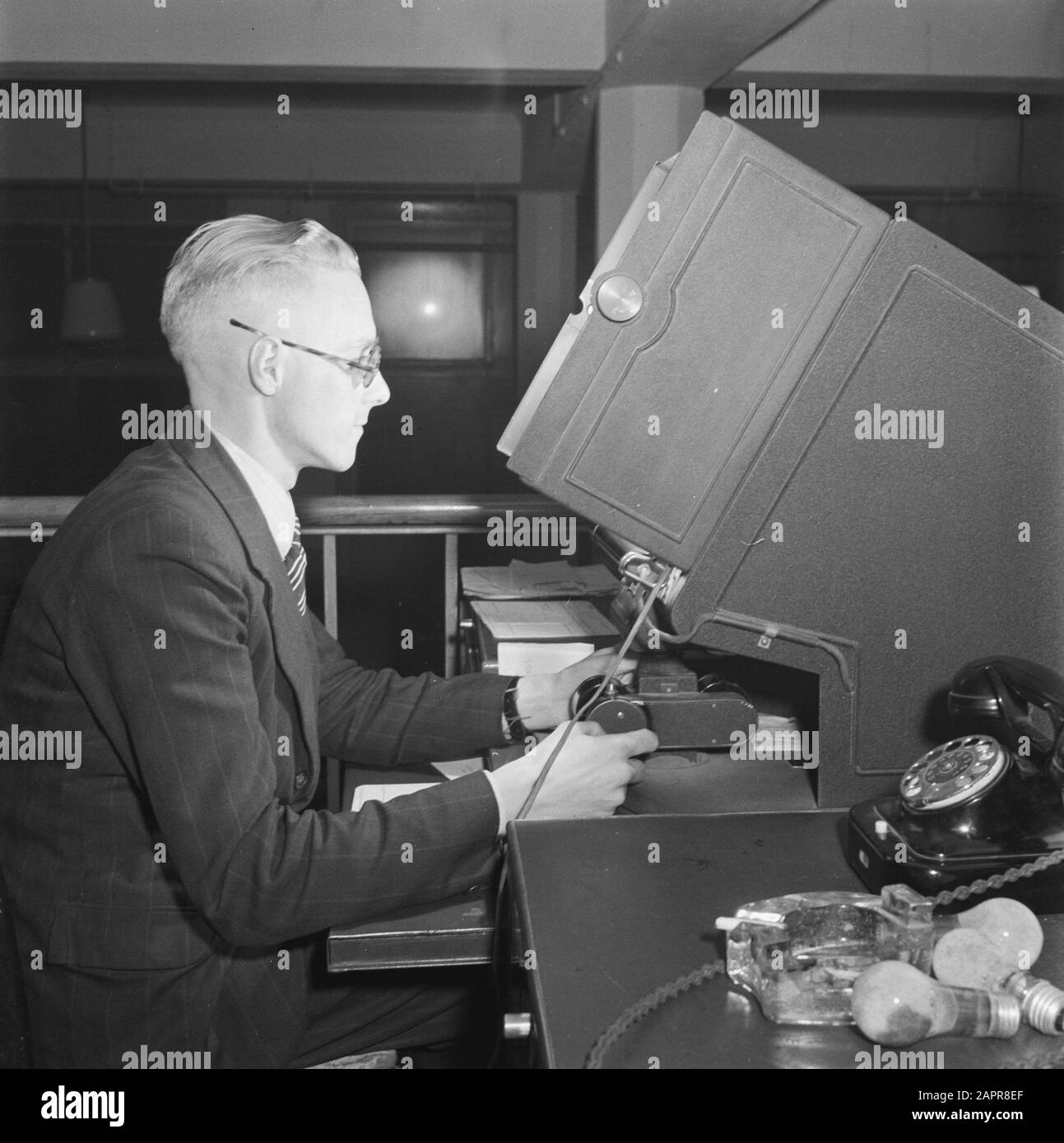 Préparatifs des premières élections de la deuxième chambre après la guerre Préparatifs des premières élections de la deuxième chambre après la guerre. Les bonnes élections sont fondées sur des registres de population fiables. De par la nature de la question, beaucoup de choses ont changé ici au cours des cinq dernières années. Sur la base d'un film étroit sur lequel la plupart des données des registres de population avaient déjà été enregistrées avant la guerre, les carthotiques sont remis en ordre. Un fonctionnaire de l'appareil ingénieux avec lequel les données du film sont reproduites en taille réelle Date: 6 novembre 1945 lieu: Amsterdam, Banque D'Images