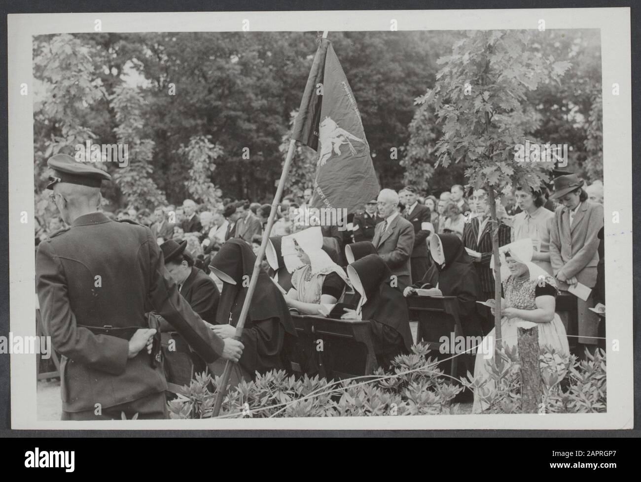 Arnhem '45, bataille d'Arnhem Solemn commémoration de la bataille d'Arnhem au cimetière aéroporté d'Oosterbeek, en présence de 50 soldats anglais. La foule priante pour le drapeau aéroporté Annotation: On paws sit nuns and women in Zeeland costume Date: 17 septembre 1947 lieu: Oosterbeek mots clés: Guerres, guerre Banque D'Images