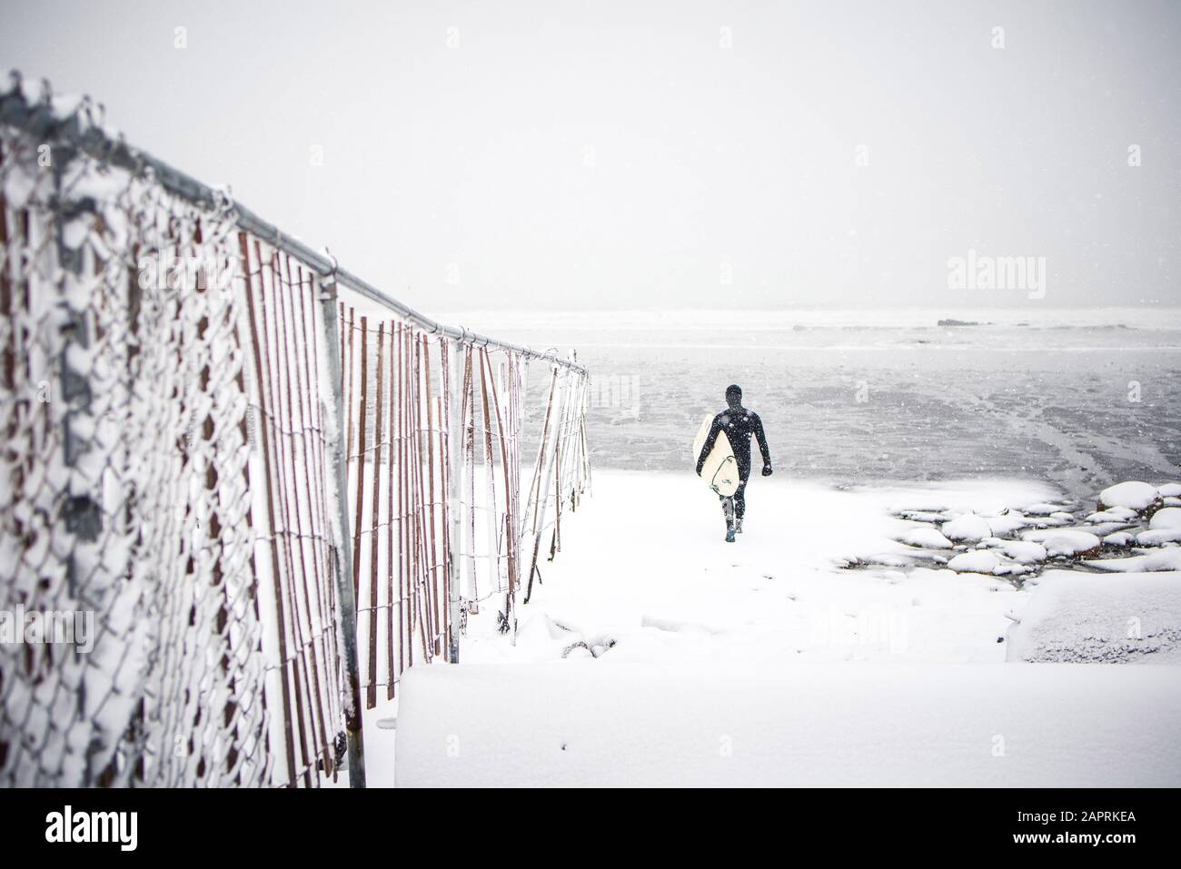 Les surfeurs se promène le long de la plage du Maine pendant la tempête de neige hivernale Banque D'Images