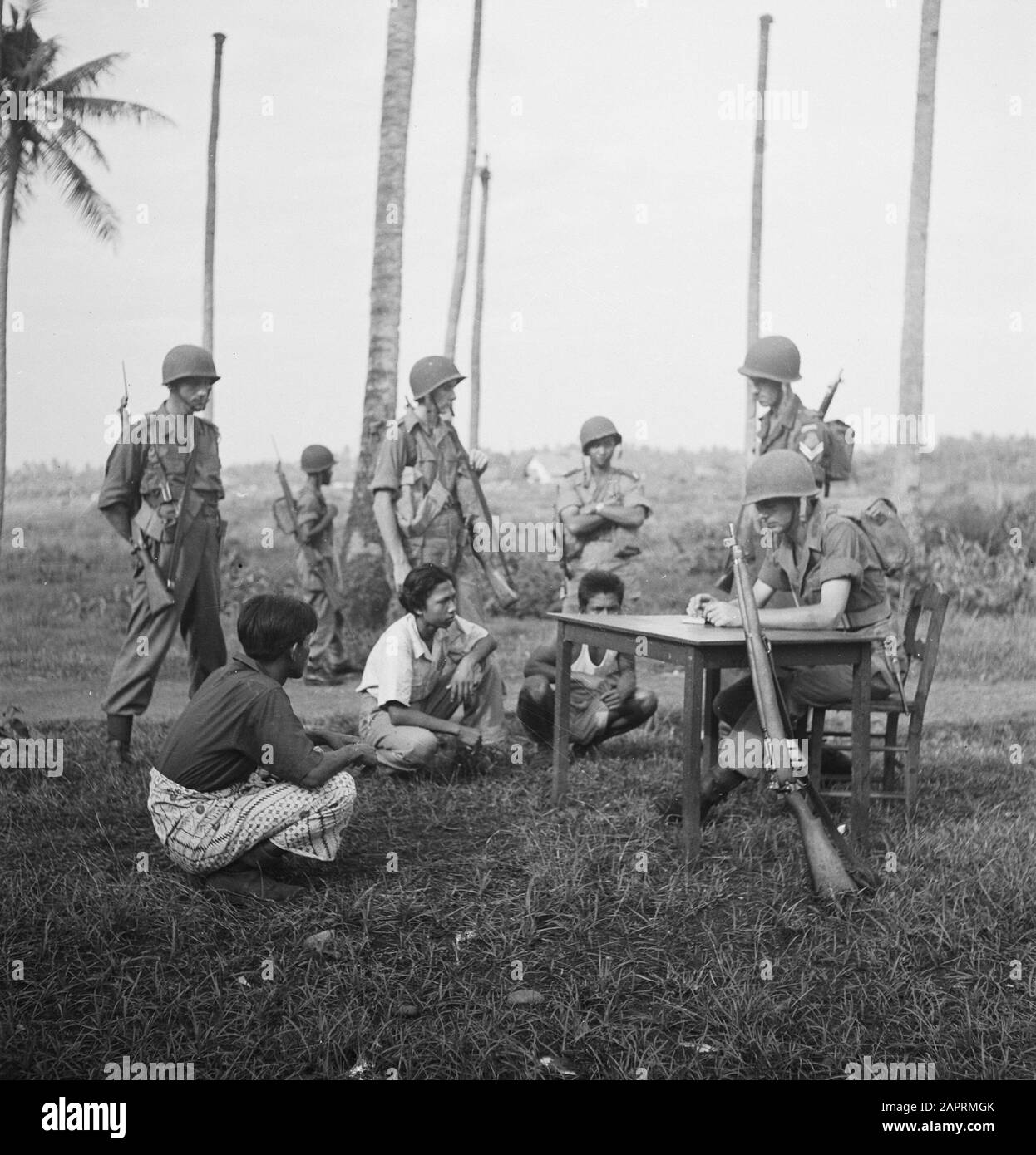 T.V.A. [Trois Indonésiens sont assis sur le terrain. Un soldat néerlandais est assis derrière une table et fait des notes Quatre soldats armés se tenant autour de lui] [N'a Jamais intermonté plus d'un prisonnier à la fois... et ne laissez jamais le défendeur squat... mais ASSEYEZ-VOUS! Assis, il est plus difficile de sauter vers le haut que de squatter. Aucune arme à portée des suspects!] Annotation: V.P.T.L. = Exigence pour l'exercice de la tâche de police politique de l'armée (action contre les combattants de guérilla). Cette règle de KNIL remonte à 1928, est apparue en 1936 et a été modifiée et complétée en 1945 et publiée à nouveau en 1946, maintenant particulièrement Banque D'Images