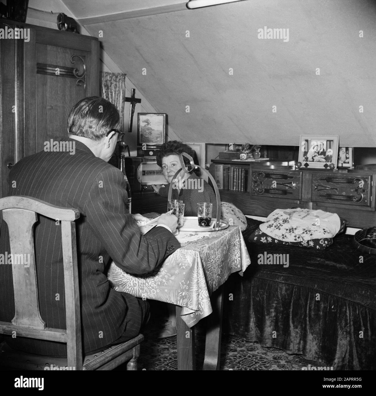 Résidents d'un immeuble d'appartements à Paris Couple Marié à la table dans le salon Date: 1950 lieu: France, Paris mots clés: Couples, intérieurs, ensembles radio, tables, maisons Banque D'Images