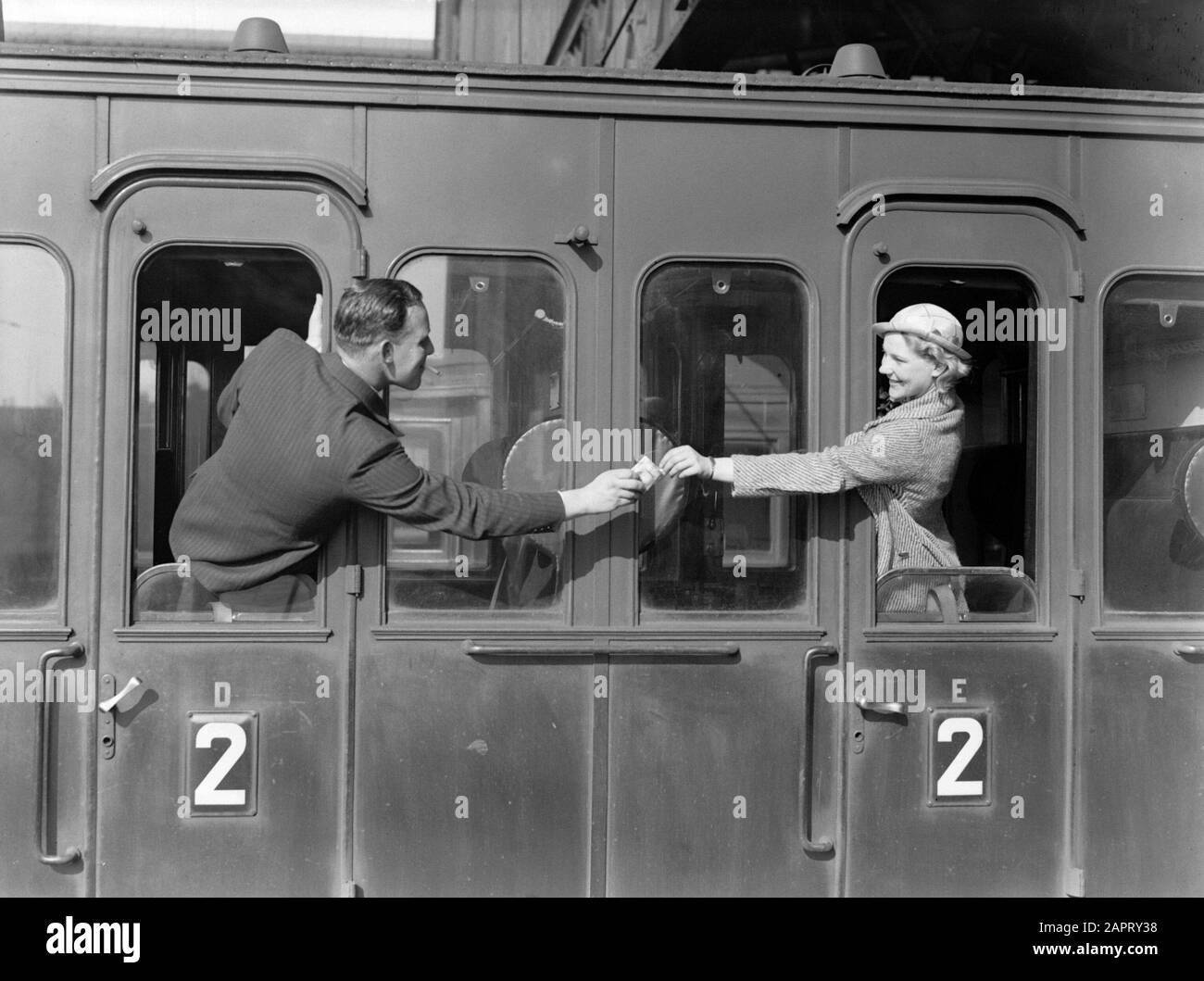 Publicité Photographie UN homme donne au modèle Eva Waldschmidt une cigarette à travers la porte d'un train coupé Annotation: Peut-être la publicité pour la marque de cigarette État du Nord Date: 1932 mots clés: Photo modèles, fenêtres, cigarettes, trains Nom personnel: Waldschmidt, Eva Banque D'Images