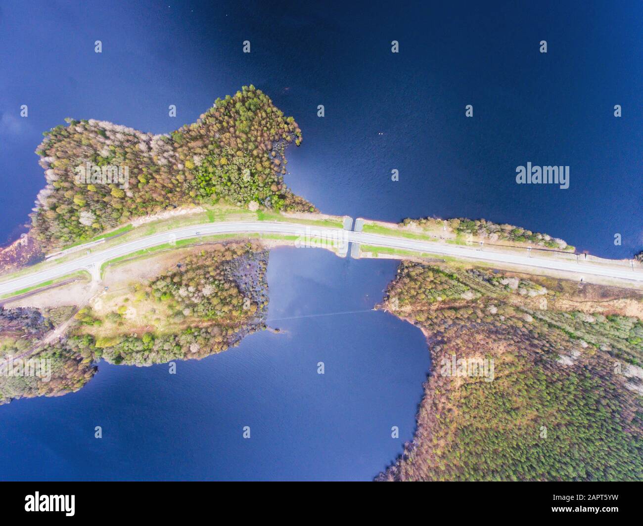 Belle vue d'une route passant par le beau lac et la forêt, entouré d'eau des deux côtés, tourné au-dessus de drone, image aérienne vibrante Banque D'Images