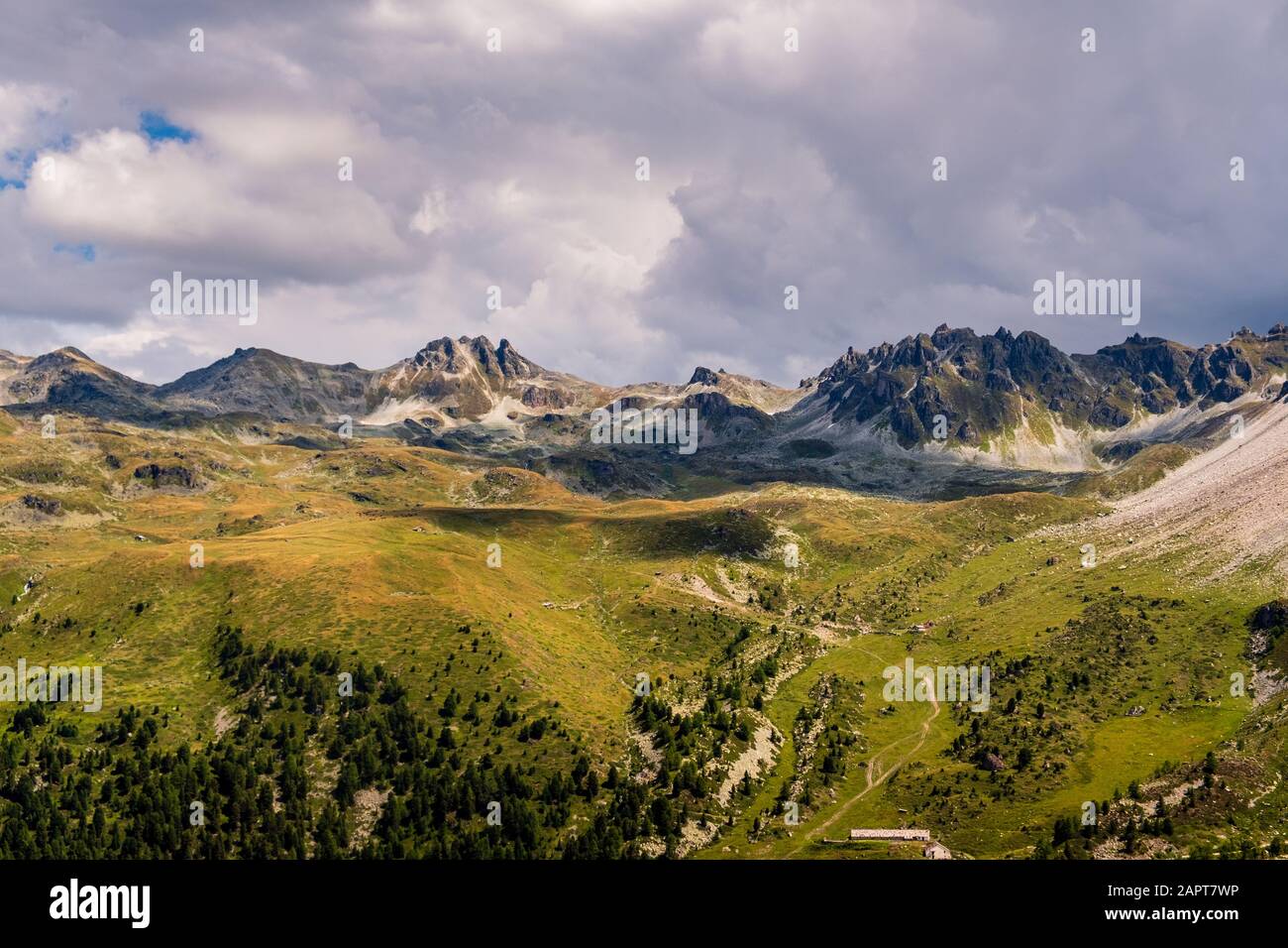 La formation de roches et les pâturages alpins se sont élevés dans les Alpes de Pennine au-dessus de Saint-Luc sous des nuages dramatiques en été. Anniviers, Valais, Suisse Banque D'Images
