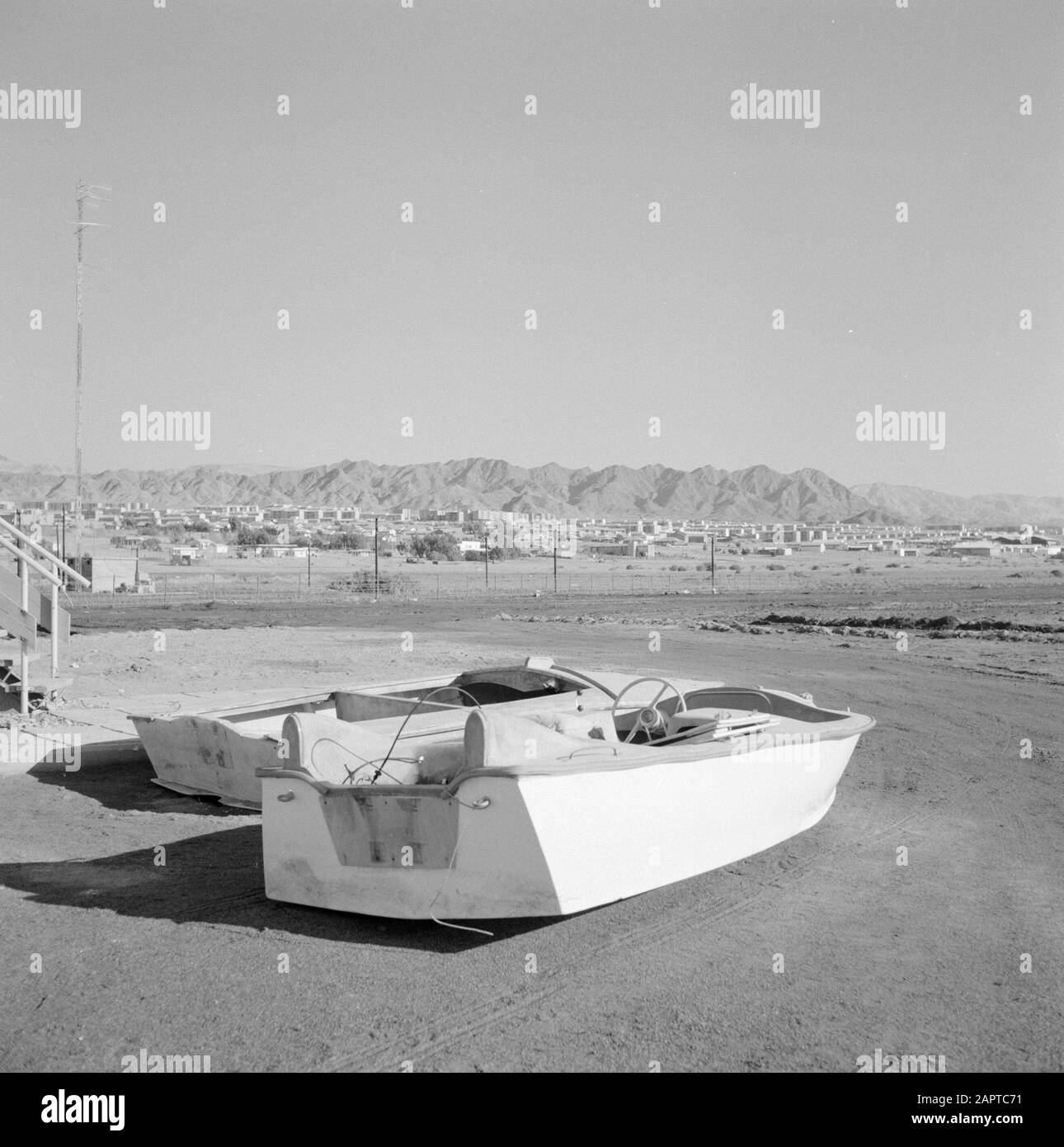Vue sur la ville d'Eilath depuis la plage. Au premier plan deux vedettes à sec Date: 1 janvier 1963 lieu: Eilat, Golfe d'Aqaba, Israël mots clés: Paysages, vedettes, plages Banque D'Images
