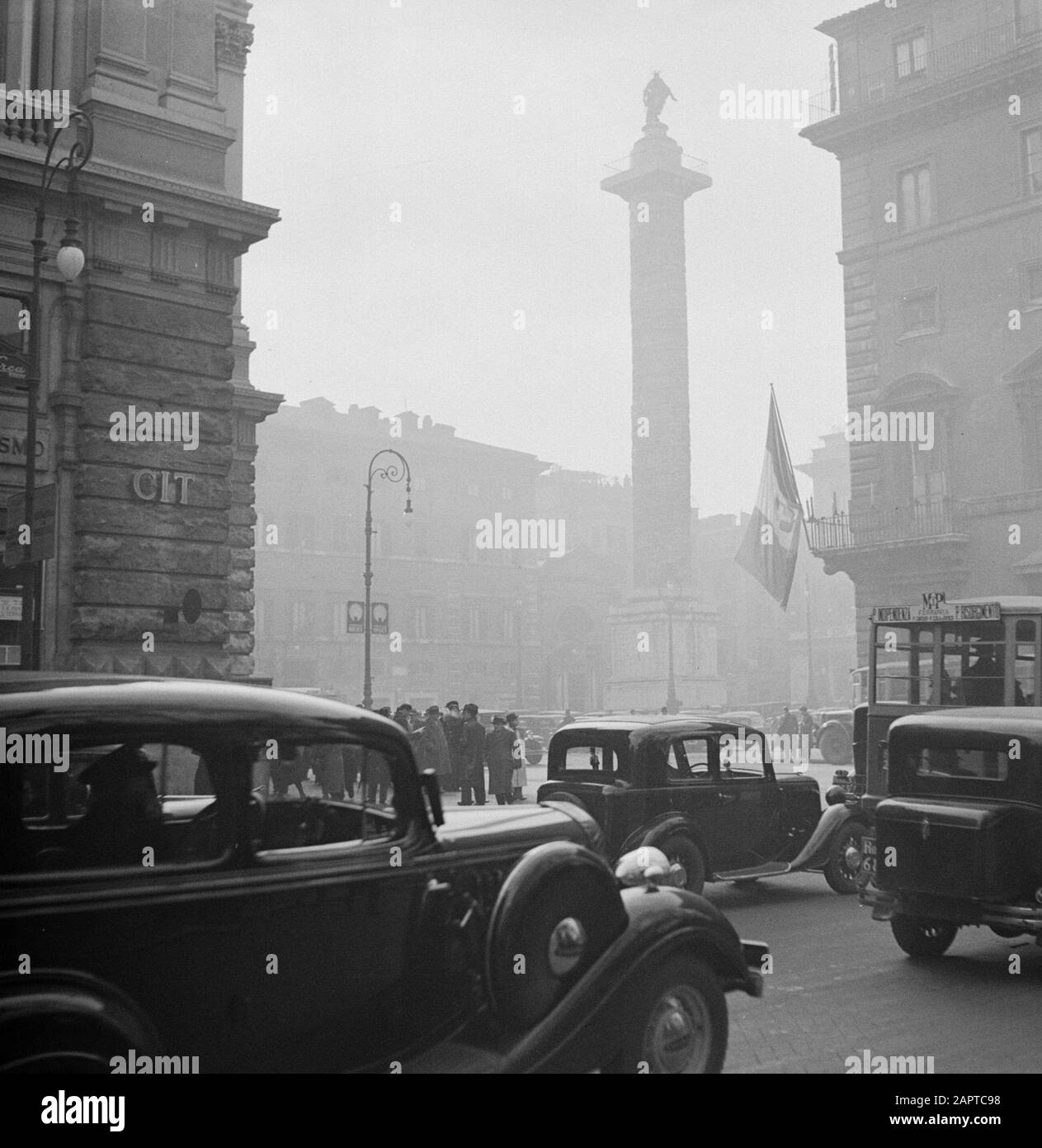 Rome: Visite de la ville vue de la colonne de Marcus Aurelius dans le brouillard à Piazza Colonna Date: Décembre 1937 lieu: Italie, Rome mots clés: Voitures, bâtiments, brouillard, places, sculptures de rue Banque D'Images