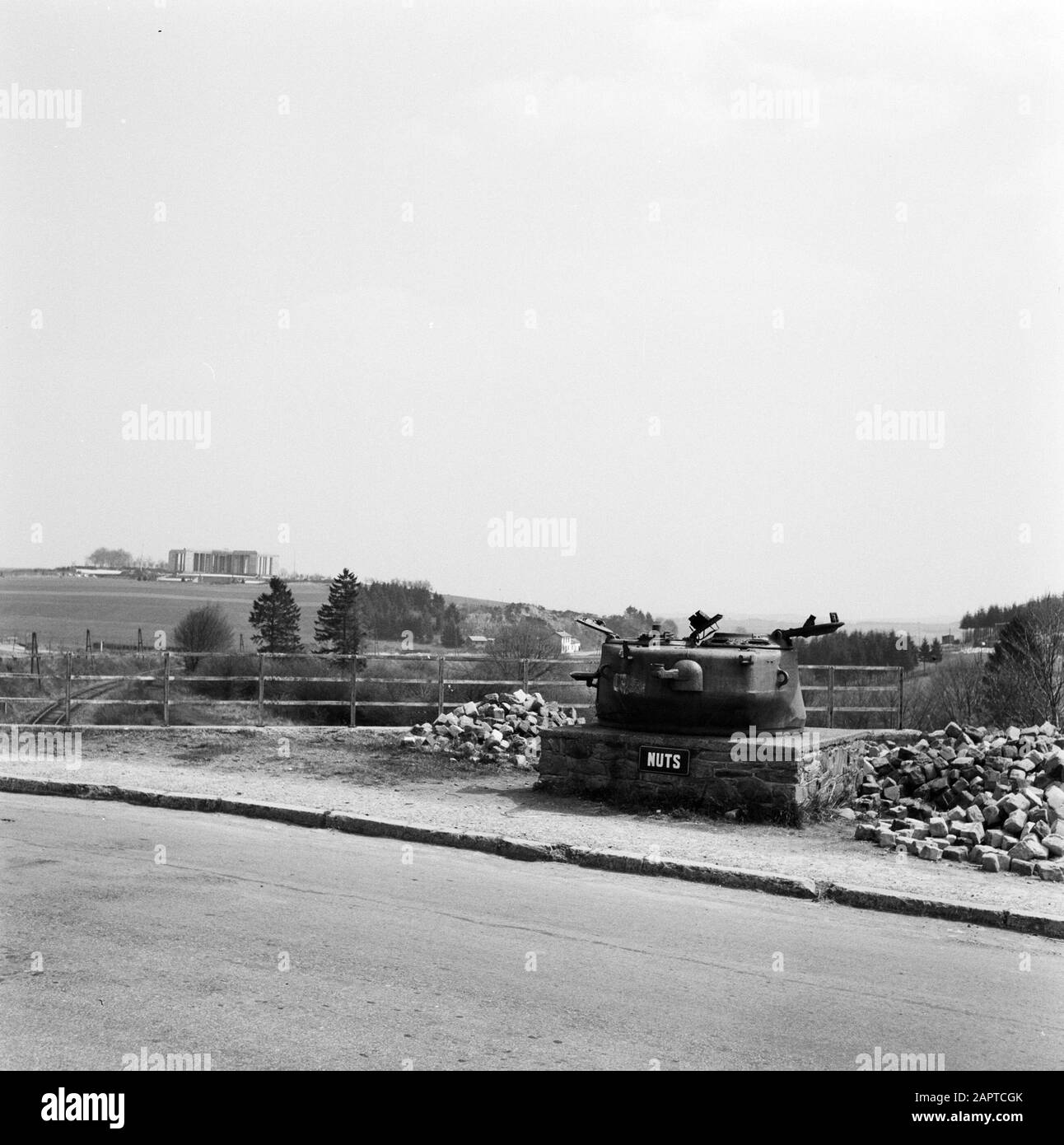 Mémorial du Mardasson, le mémorial de la guerre des États-Unis à Bastogne, Belgique vue du monument à l'horizon; à côté de la route une élévation de brique avec la tourelle d'un réservoir incluant le mot NUTS état écrit: "Les écrous (absurdités) se réfère à la réponse donnée par le général américain A.C. McAuliffe à la demande allemande de reddition à la bataille de Bastogne en décembre 1944 Date: 1956 lieu: Bastogne, Belgique mots clés: Monuments, panoramas, chars Banque D'Images