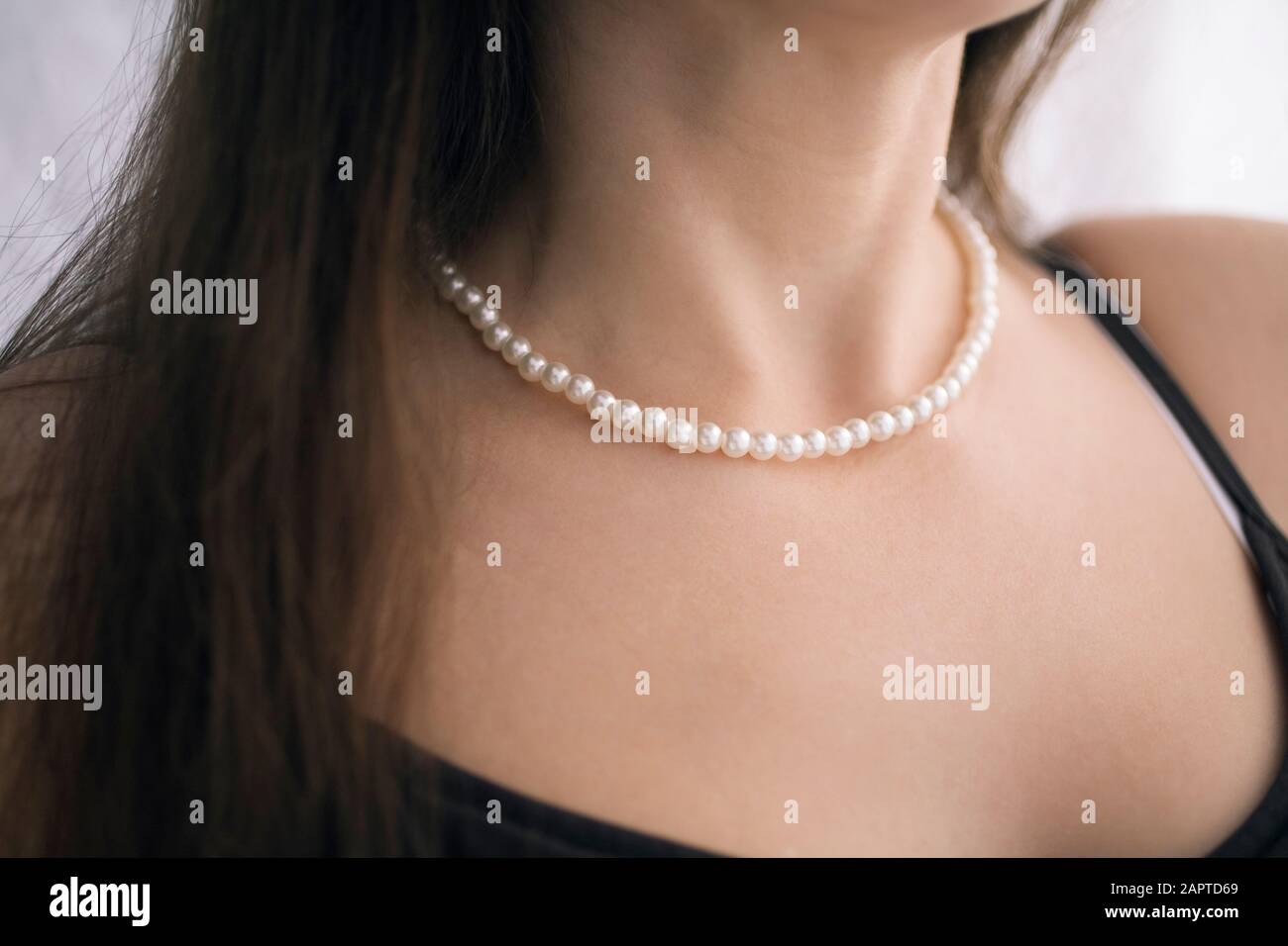 Section médiane d'une femme portant un collier de perles. Banque D'Images