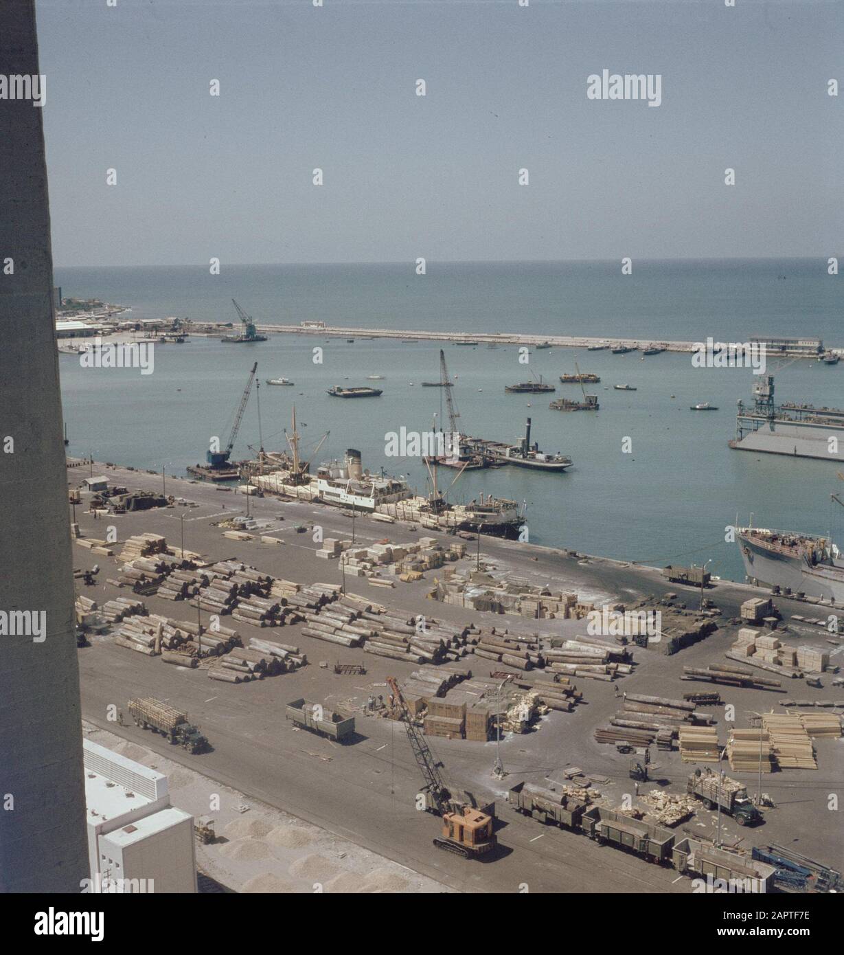 Haïfa. Vue sur le quai du port avec bateaux amarrés en bois. Sur le quai sont de grands lots de bois stockés Date: Non dédrée lieu: Haïfa, Israël mots clés: Ports, bois, commerce du bois, quais, panoramas, navires de fret Banque D'Images