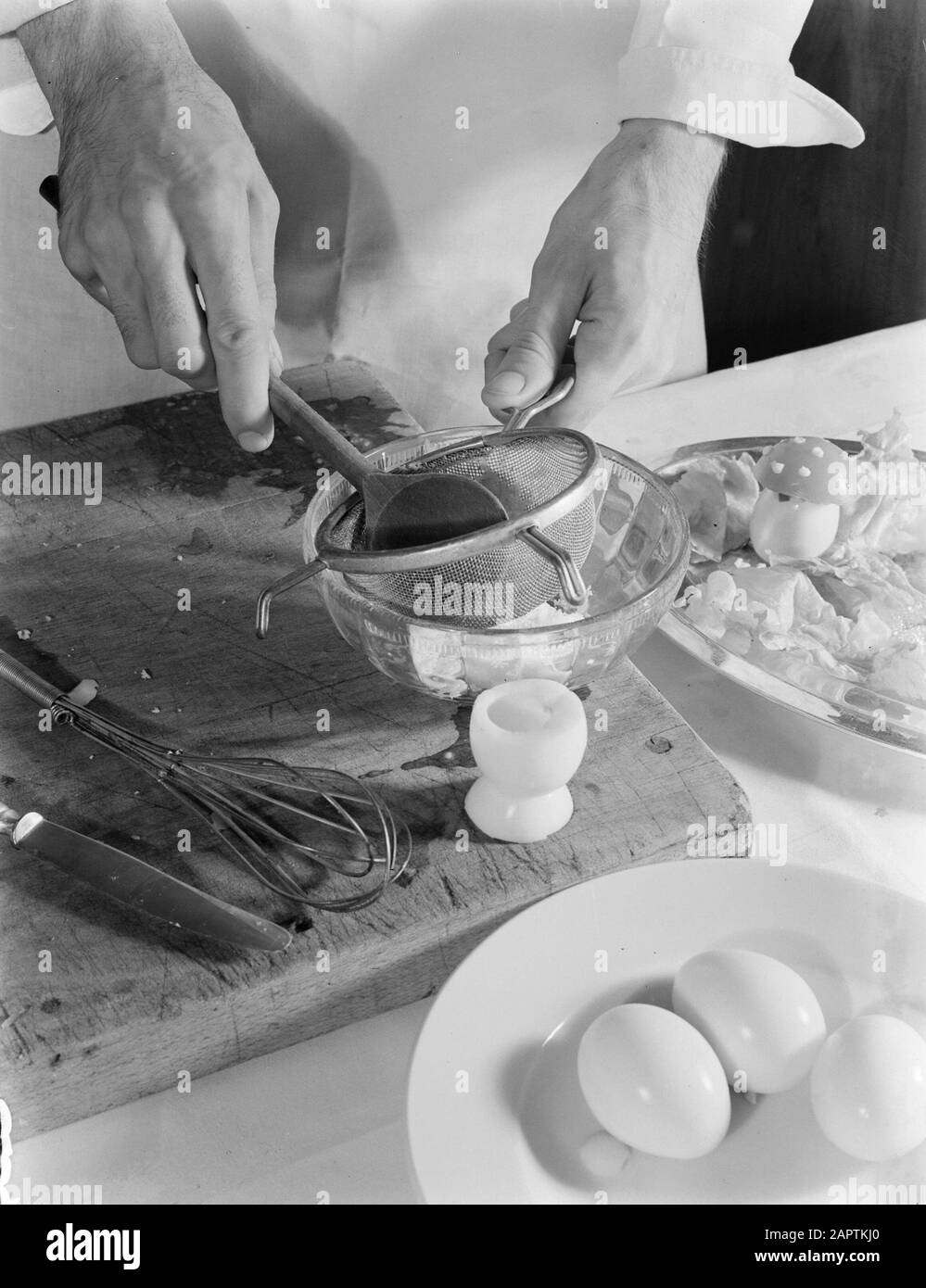 Publicité photographie Faire un plat avec des oeufs farcis: Poncer des oeufs bouillis Annotation: Photos faites pour un livre de cuisine par l'édition Veen Date: 1936 mots clés: Oeufs, préparation de nourriture Banque D'Images