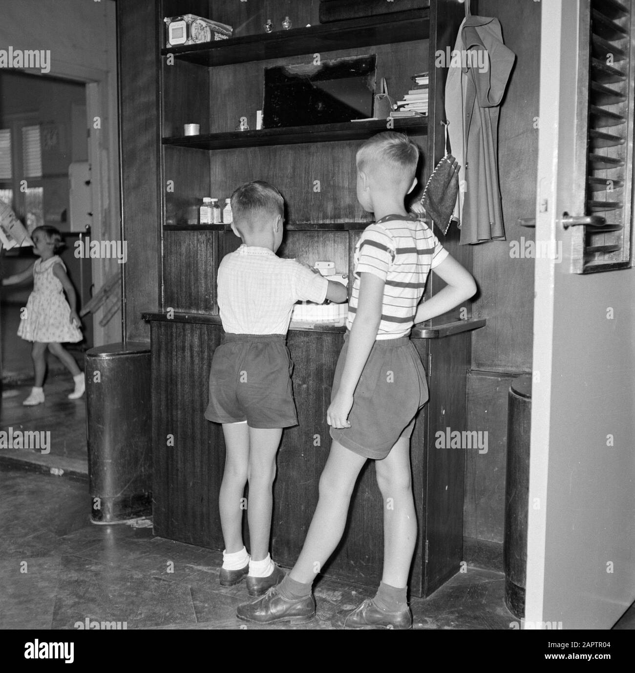 Antilles néerlandaises et Suriname au moment de la visite royale de la Reine Juliana et du Prince Bernhard en 1955 Huib (à gauche) et Thomas Struycken, fils du gouverneur, près d'une fontaine. En arrière-plan leur sœur Pia Date: Octobre 1955 lieu: Curaçao, Willemstad mots clés: Enfants, sanitaires Nom personnel: Struycken, Huib, Struycken, Thomas Banque D'Images