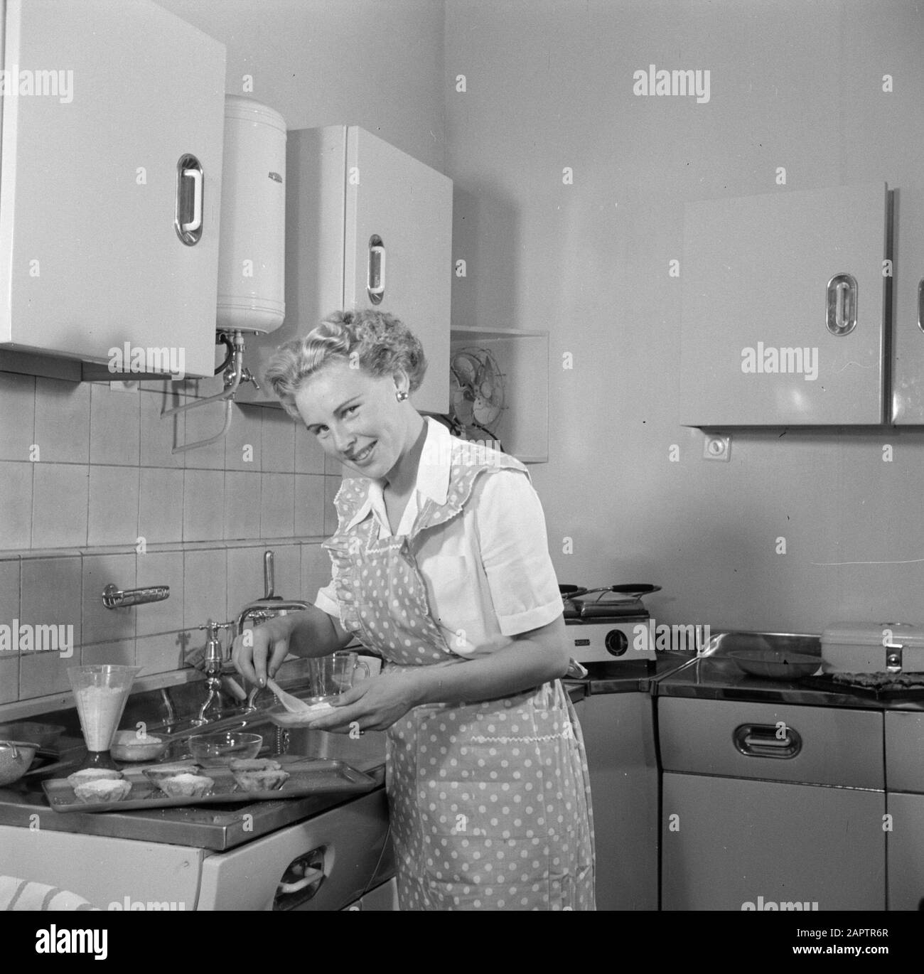 Publicité photographie Housewife dans la cuisine modèle faire un gâteau. Annotation: Photo faite pour la publication "Nous bakken itelemes" écrit par R. Lotgering-Hillebrand et publié par l'éditeur van Holkema & Warendorf Date: 1 juin 1953 mots clés: Cuisines, préparation de nourriture, femmes Banque D'Images