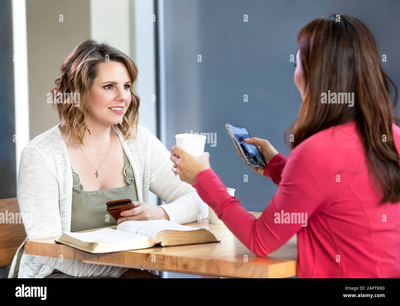 Deux collègues discutent de ce qu'ils ont appris après avoir fait une étude biblique ensemble dans un café d'église : Edmonton, Alberta, Canada Banque D'Images