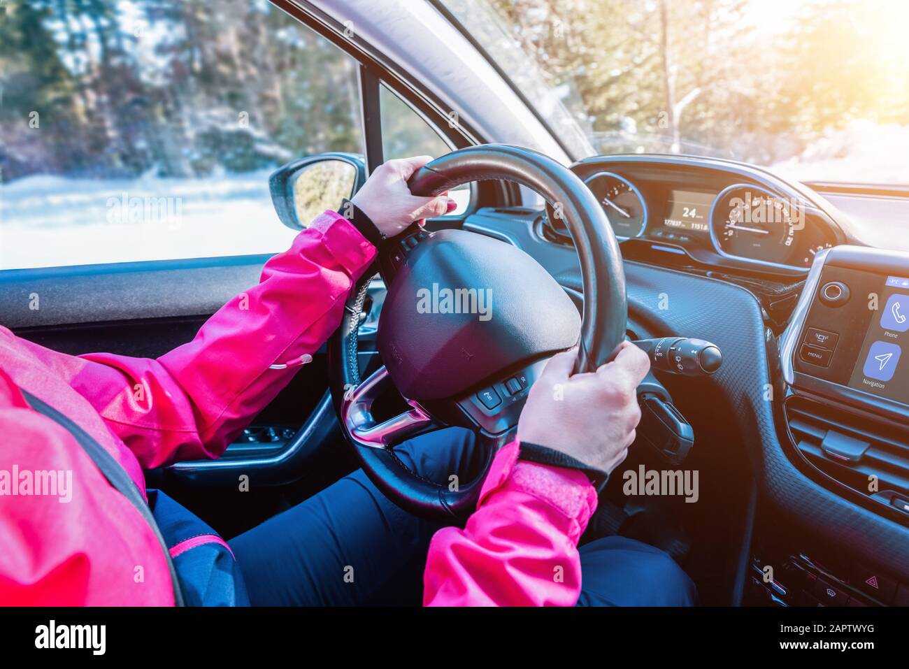 Femme mains sur le volant de la voiture. Intérieur de voiture moderne avec tableau de bord intelligent. Concept d'hiver, aventure de voyage Banque D'Images