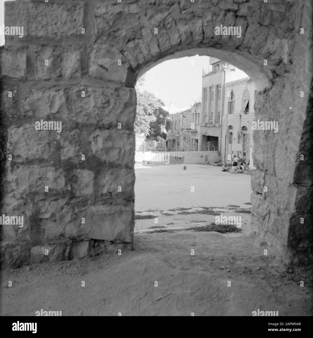 Israël 1964-1965: Jérusalem (Jérusalem), La Désintégration De Jérusalem. Vue à travers une porte donnant sur le mur barbelé de fil construit de l'autre côté de la route comme partition entre les parties israéliennes et jordaniennes de Jérusalem Date: 1964 lieu: Israël, Jérusalem, Jordanie mots clés: Enfants, murs, portes, barbelés, maisons Banque D'Images
