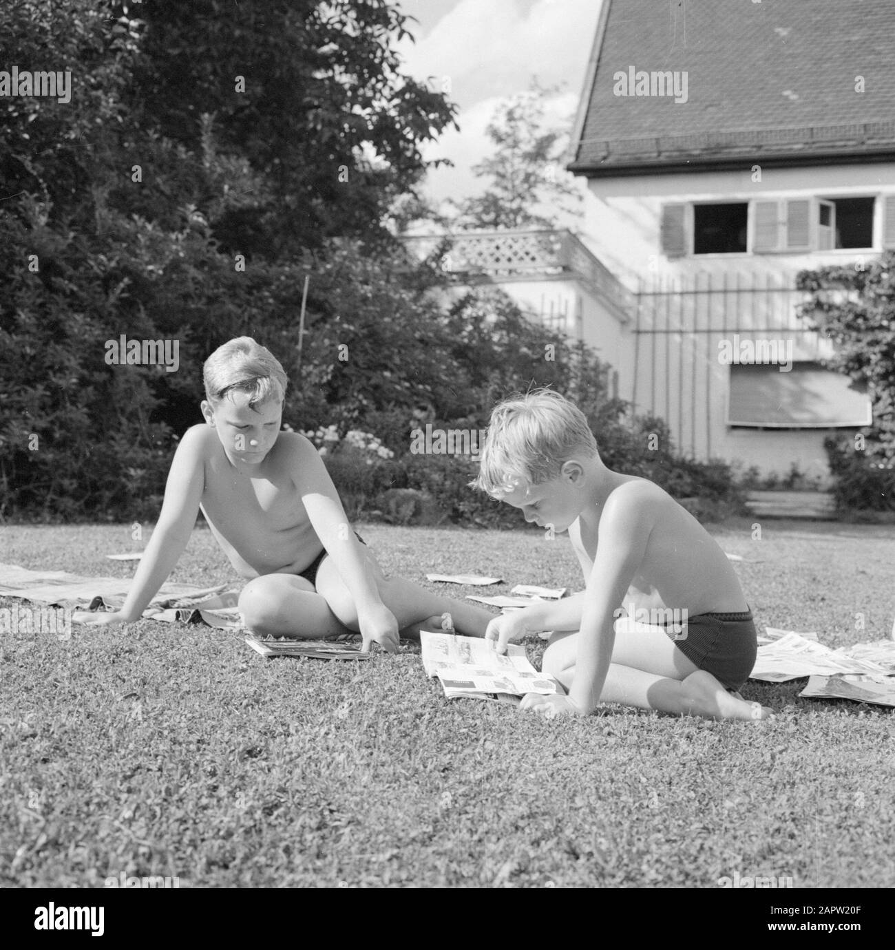 Visite à Icking Boys Kreisselmeier assis sur l'herbe lire dans des magazines et des magazines modèles Date: Juin 1964 lieu: Allemagne, Munich, Allemagne de l'Ouest mots clés: Pelouses, garçons, lecture, bandes dessinées, magazines, jardins, loisirs, maisons Banque D'Images