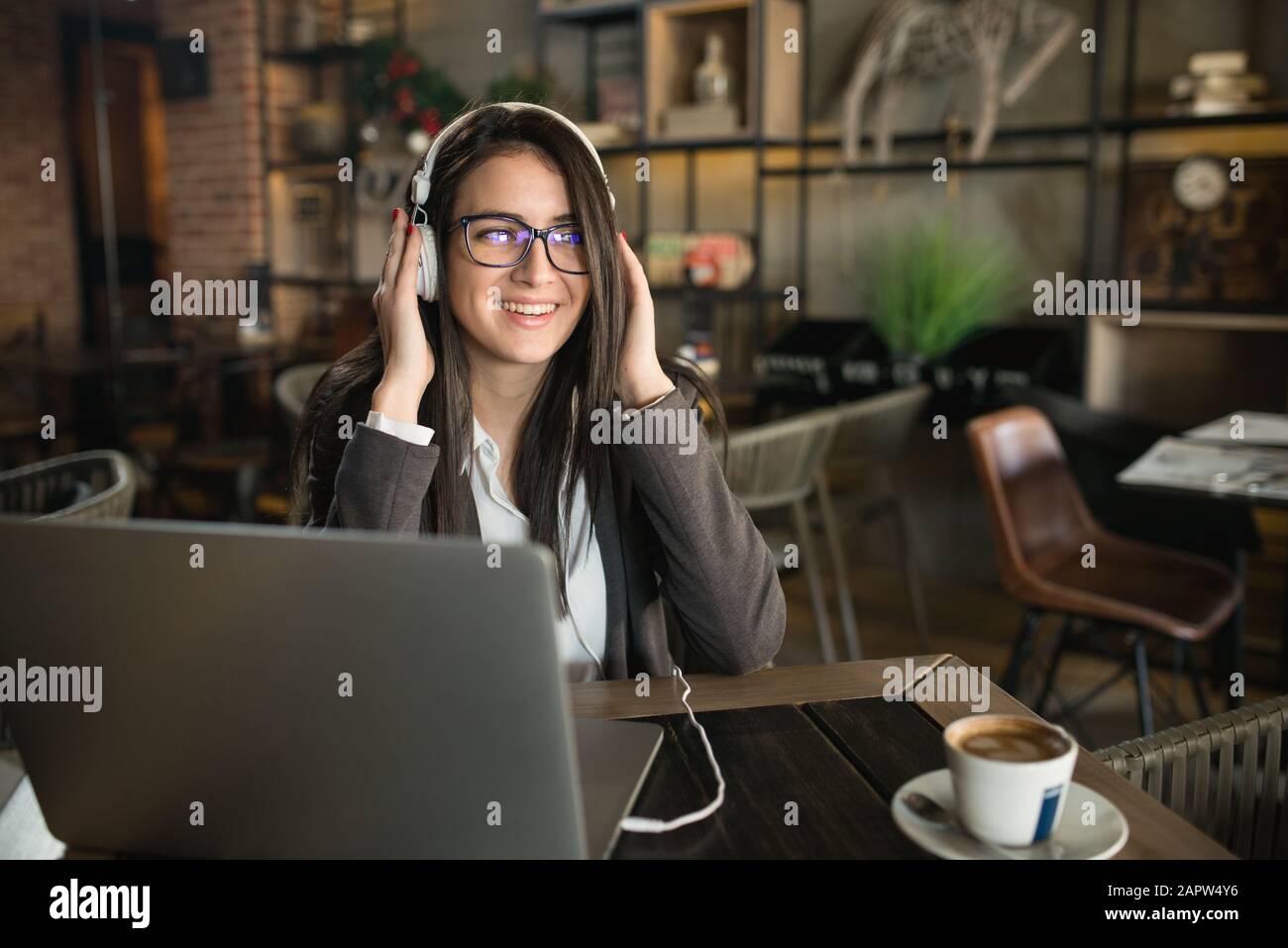 Portrait de la jeune femme qui boit du café et écoute de la musique Banque D'Images