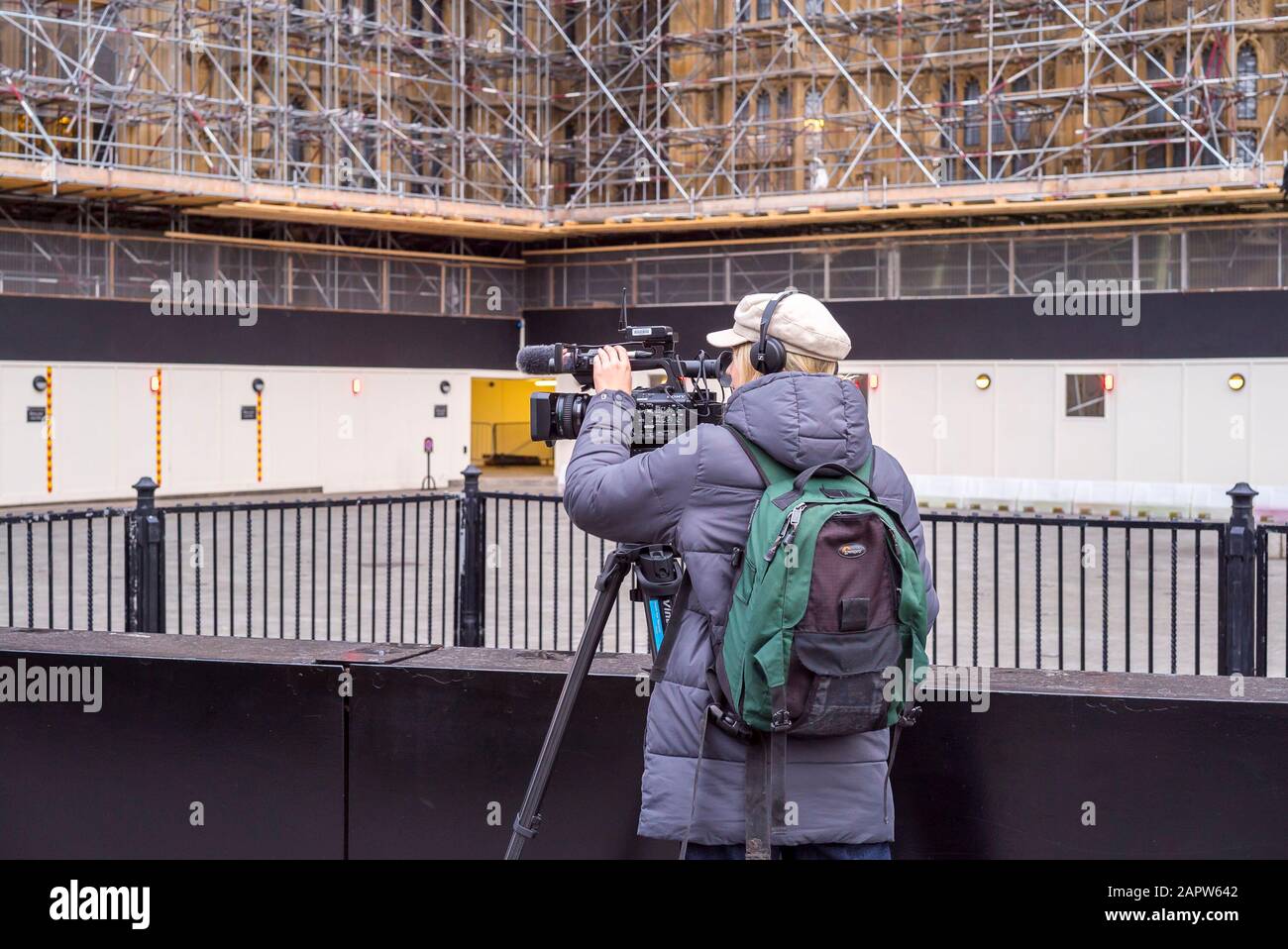Royaume-Uni professions: Camérawoman isolé filmant en dehors des Chambres du Parlement, Westminster Royaume-Uni, recouvert d'échafaudages. Femme dans le rôle masculin. Les femmes qui travaillent. Banque D'Images