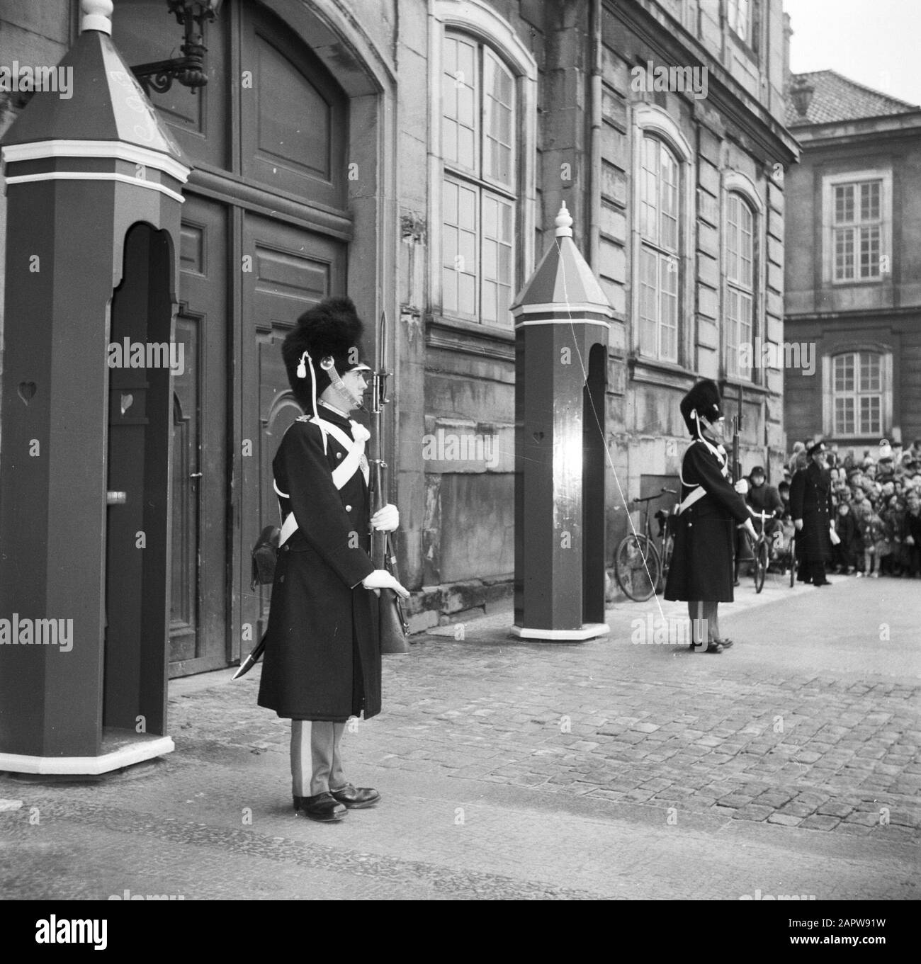 55ème anniversaire de la Garde royale du roi Frederick IX à la porte d'entrée du palais Brockdorff sur la place du château Amalienborg Date : 11 mars 1954 lieu : Danemark, Copenhague mots clés : surveillance, portes, gardes honoraires, coiffures, militaires, palais, public, statues de rue, uniformes, armes à feu Banque D'Images