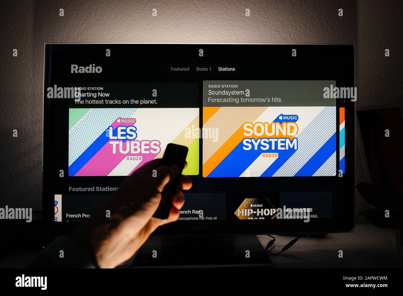 Paris, France - Circa 2019: Utilisation de la télécommande sur le menu  Apple TV sur le salon Panasonic TV plasma avec les 100 meilleures cartes  chartes Charting Now et la radio prévisions