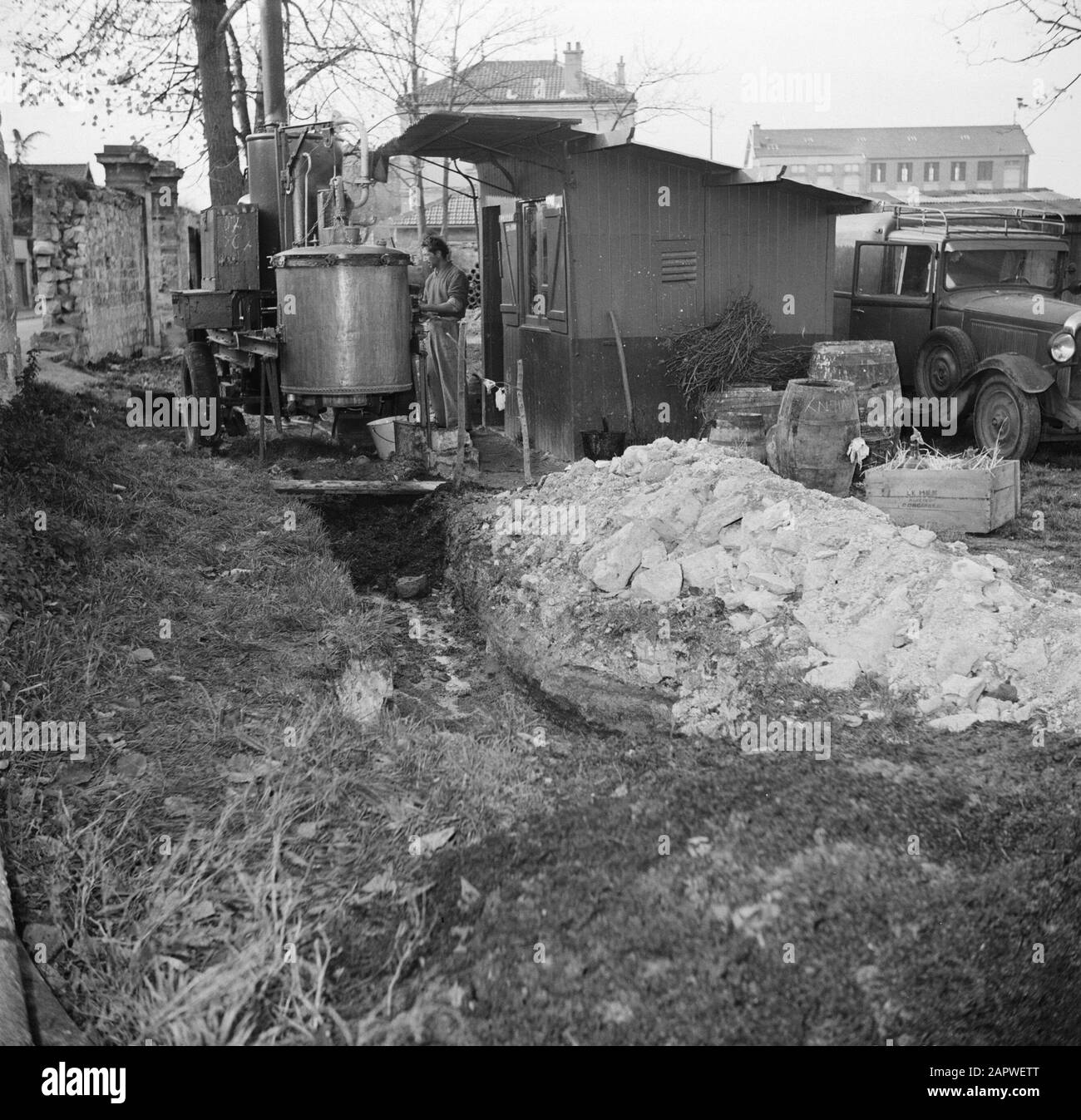bouilloire de distillation en plein air Homme debout entre le sac et la bouilloire de distillation Date: 1950 lieu: France, Paris mots clés: Alcool, distilleries, hommes Banque D'Images
