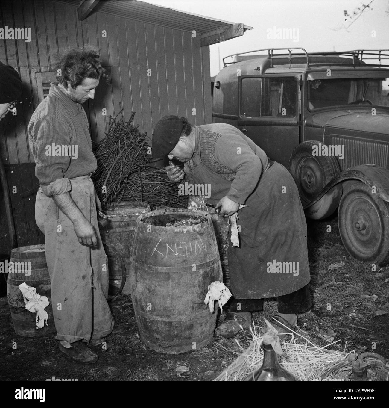 bouilloire de distillation en plein air hommes avec un baril de charbon Date: 1950 lieu: France, Paris mots clés: Voitures, sabots, hommes, charbon Banque D'Images