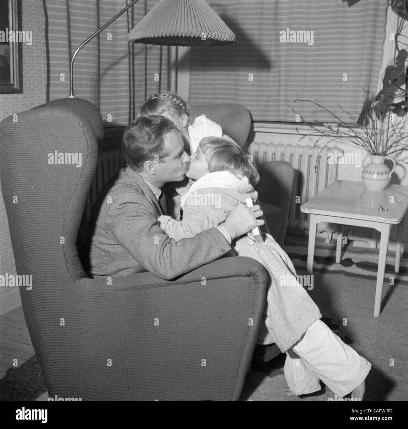 Jour dans la vie de la famille Svendsen M. Svendsen donne à sa plus jeune fille un baiser, vraisemblablement avant le coucher Date: Mars 1954 lieu: Danemark mots clés: Vie quotidienne, filles, familles, maison, maison, maison, maison, maison Nom personnel: Svendsen, Banque D'Images