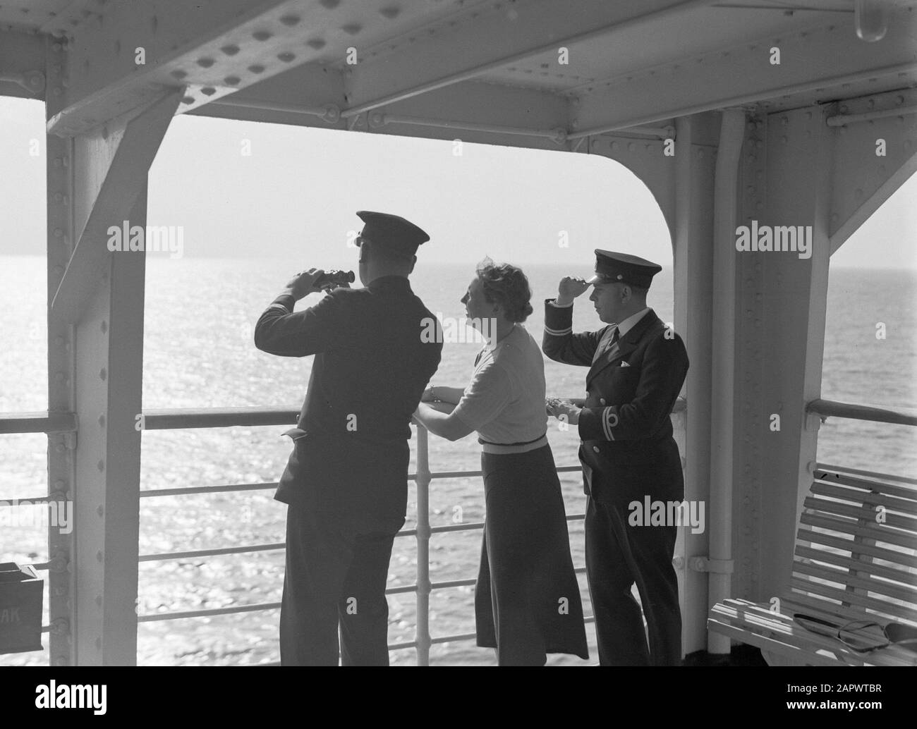 Voyage en mer avec Mme Baloeran Nell Langlais, la femme de Van de Poll, avec la visionneuse à côté de deux officiers Annotation: Cette photo fait partie d'une série de photos d'un voyage avec la MS Baloeran du système de transport de passagers Date: 1935 mots clés: Capitaines, navires à passagers, jumelles Nom personnel: Langlais, Nell Banque D'Images