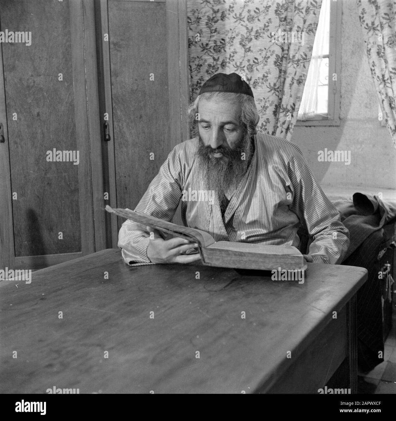 Israël 1948-1949: Le rabbin et scribe d'Europe de l'est de Jérusalem dans le district de Mea Shearim, assis à la table Date: 1948 lieu: Israël, Jérusalem, Mea Shearim mots clés: Barbes, livres, coiffures, rabbis, tables Banque D'Images