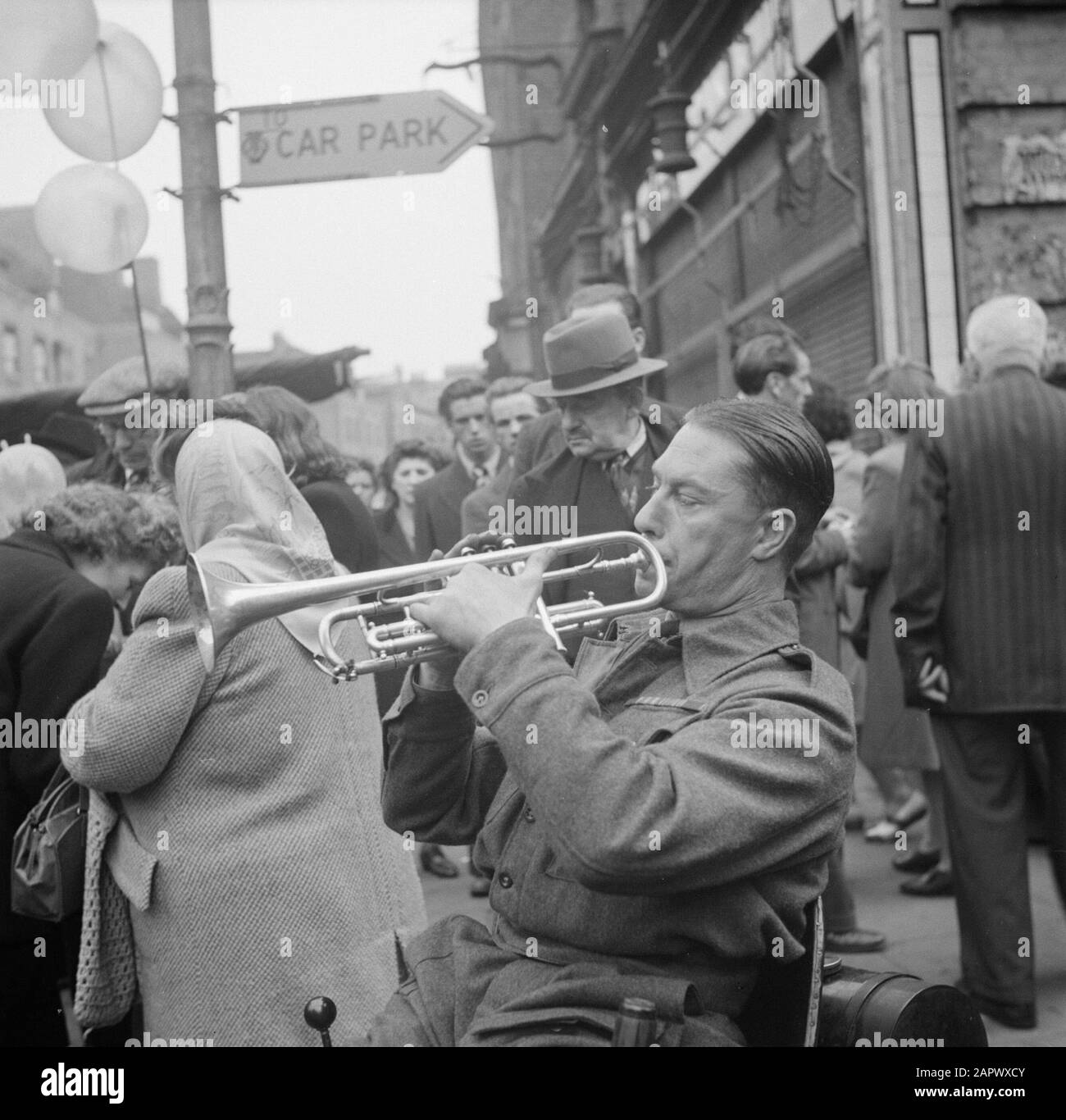 Market in Petticoat Lane, London War non valide dans fauteuil roulant joue trompette sur le marché Date: 1947 lieu: Angleterre, Londres mots clés: Désactivé, marchés, musiciens, trompettes Banque D'Images