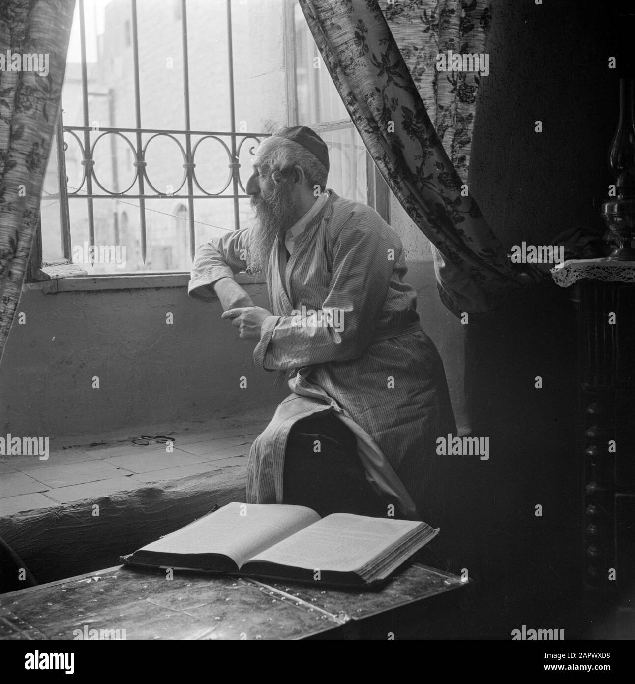 Israël 1948-1949: Le rabbin et le scribe d'Europe de l'est de Jérusalem dans le district de Mea Shearim, assis par une fenêtre Date: 1948 lieu: Israël, Jérusalem, Mea Shearim mots clés: Barbes, livres, coiffures, rabbis, fenêtres Banque D'Images