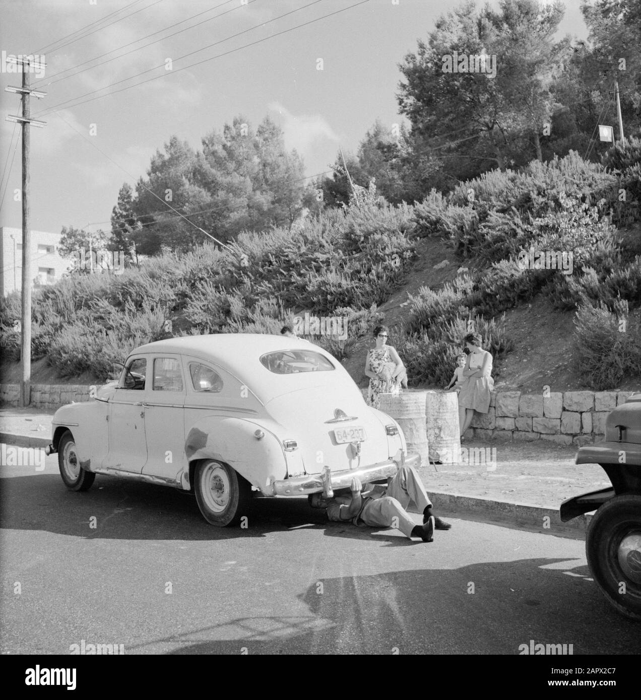 Israël 1964-1965: Tel Aviv, policiers de la rue le policier effectue un contrôle sur une voiture sur le côté de la route, les passagers attendent sur le trottoir Date: 1964 lieu: Israël, tel Aviv mots clés: Bord de route, chèques, chiens, oldtimers, barils de pétrole, voyageurs, uniformes, routes Banque D'Images