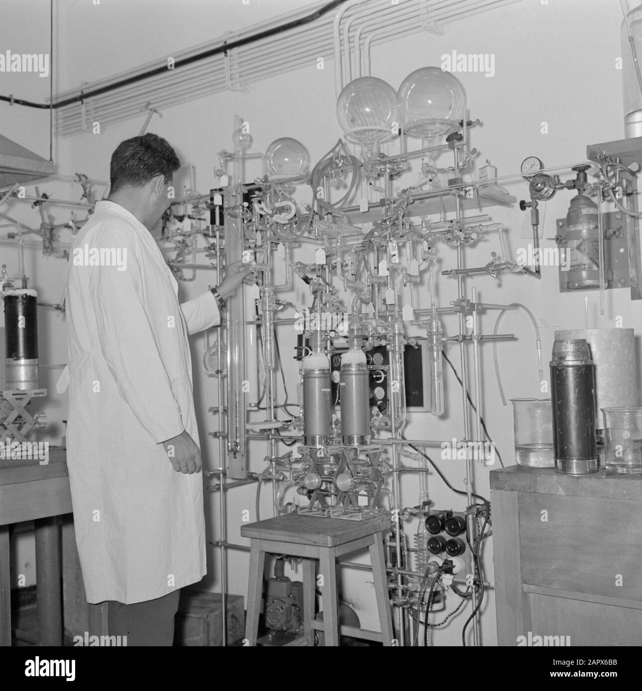 Rehovot. Institut Weizmann: L'intérieur d'un laboratoire sur le site de l'institut avec un technicien de laboratoire au travail Date: 1 janvier 1963 lieu: Israël, Rehogot mots clés: Chimie, verre, laboratoires, enseignement scientifique, recherche scientifique Nom personnel: Weizmann, Chaim : Poll, Willem van de, Banque D'Images