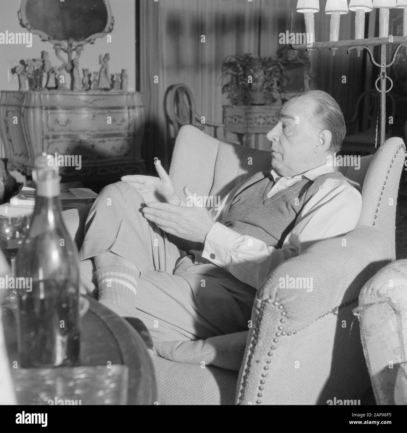 Visite de l'auteur allemand Erich Maria Remarque et de l'actrice américaine Paulette Goddard dans leur villa à Porto Ronco, Suisse Remarque en conversation, assise dans un fauteuil dans son salon dans la villa à Porto Ronco Date: Octobre 1961 lieu: Lac majeur, Suisse mots clés: Intérieurs, écrivains, maisons Nom personnel: Remarque, Erich Maria Banque D'Images