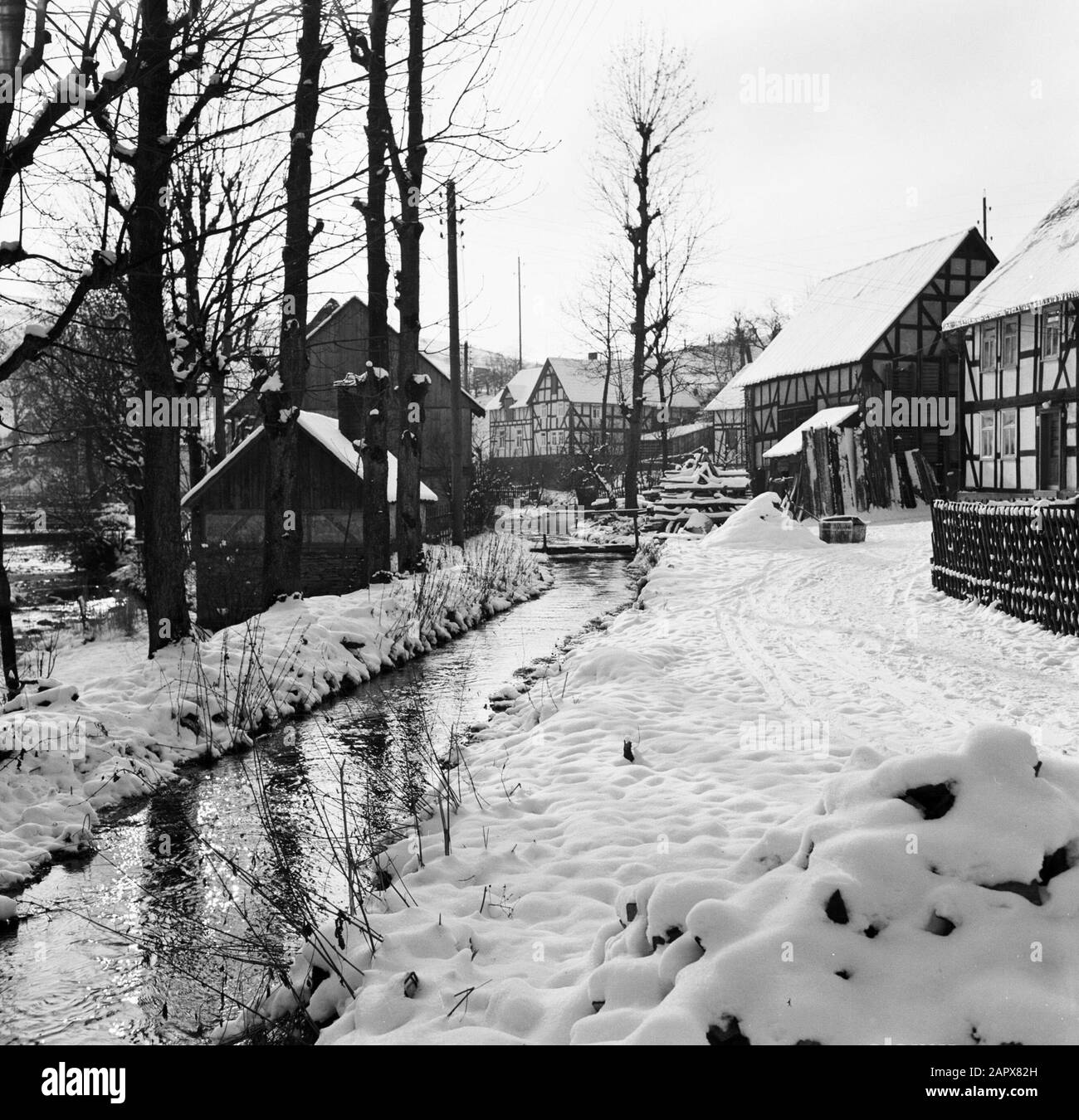 Rivière Rothaargebergte l'Odeborn avec maisons à colombages à Girkhausen en hiver Date: Non dédaignée lieu: Allemagne, Girkhausen, Rhénanie-du-Nord-Westphalie, Allemagne de l'Ouest mots clés: Ruisseaux, statues de village, neige, hiver Banque D'Images