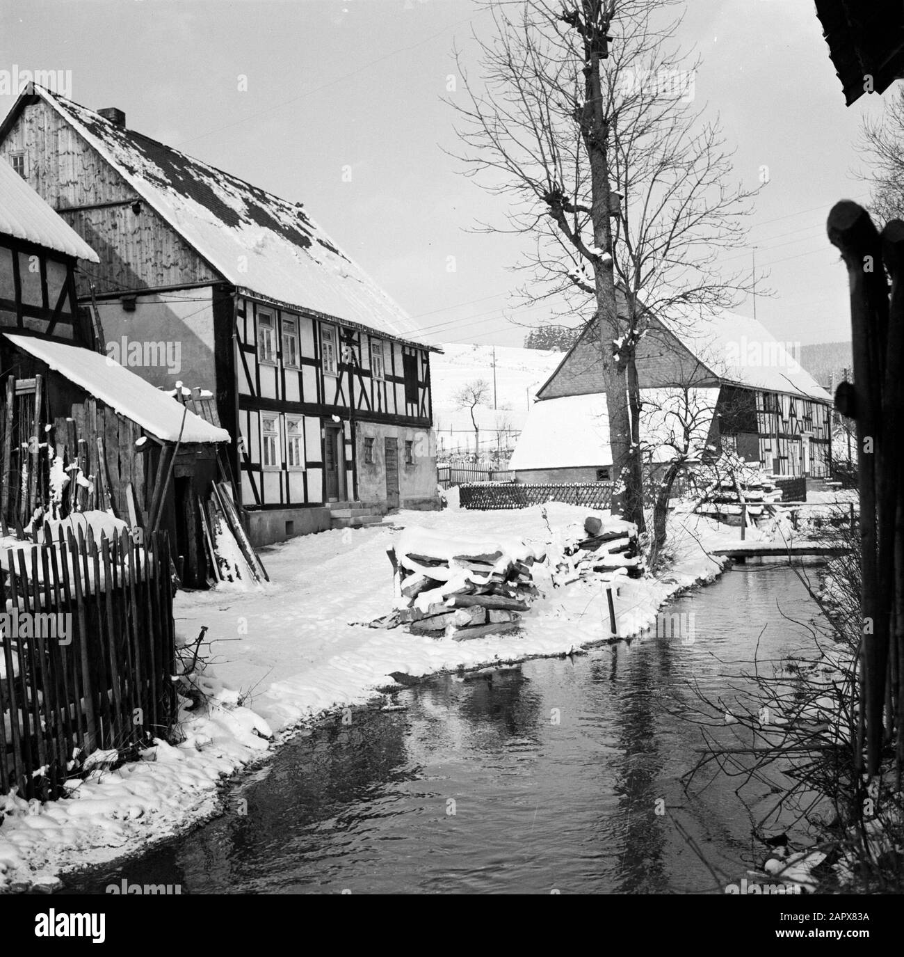 Rivière Rothaargebergte l'Odeborn avec maisons à colombages à Girkhausen en hiver Date: Non dédaignée lieu: Allemagne, Girkhausen, Rhénanie-du-Nord-Westphalie, Allemagne de l'Ouest mots clés: Ruisseaux, statues de village, neige, hiver Banque D'Images