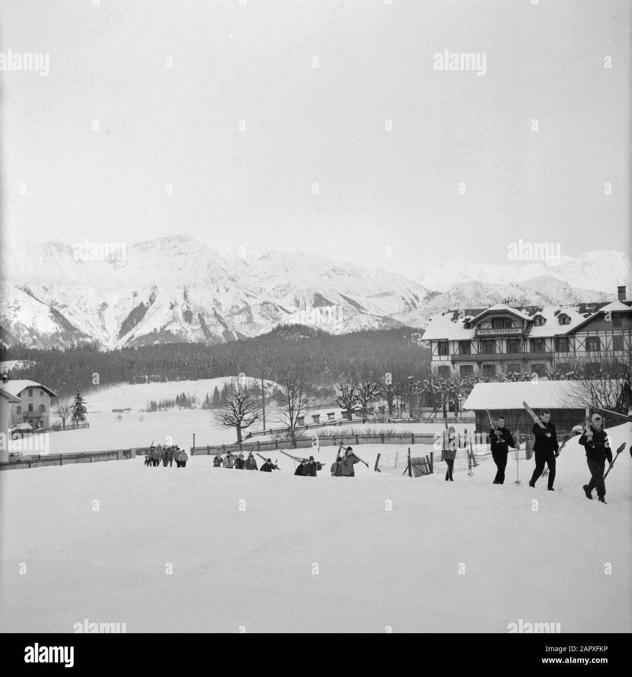 Hiver au Tyrol Skieurs marchant dans la neige avec en arrière-plan la Nordchette Date: Janvier 1960 lieu: Igls, Autriche, Tyrol mots clés: Montagnes, villages, paysages, panoramas, ski, neige, hiver, sports d'hiver Banque D'Images