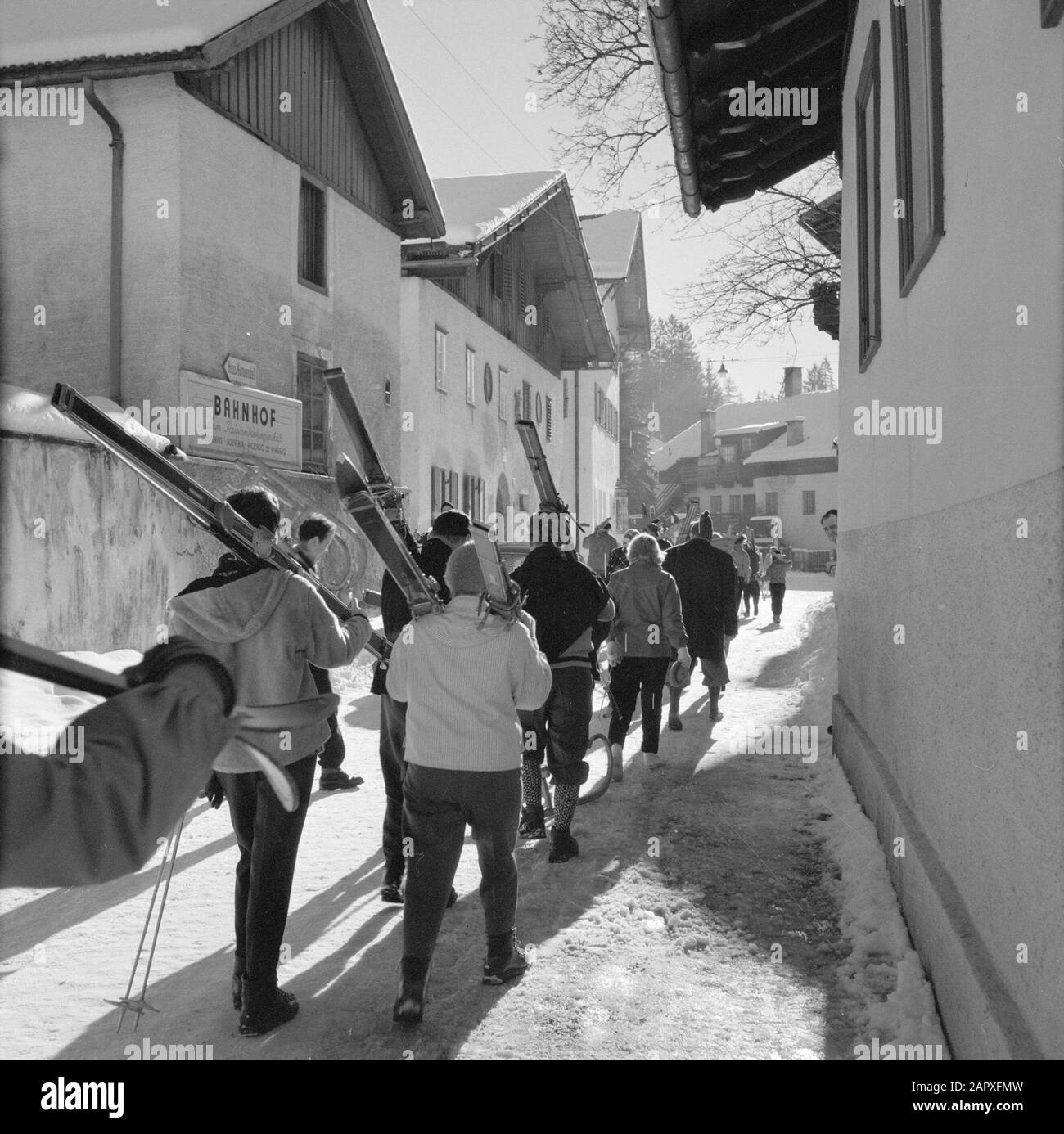 Hiver au Tyrol Skieurs marchant à travers Igls Date: Janvier 1960 lieu: Igls, Autriche, Tyrol mots clés: Montagnes, villages, ski, neige, hiver, sports d'hiver, maisons Banque D'Images