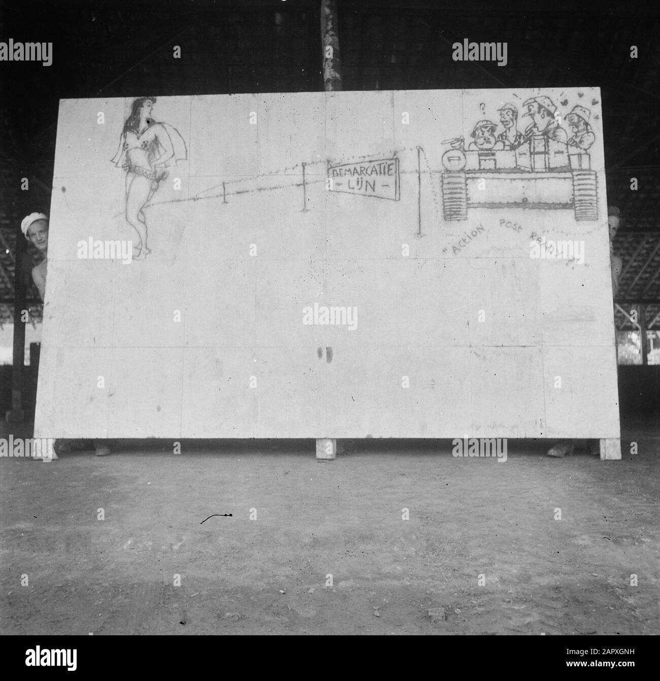 Kloeang-Sekajoe Epil Soldier regarde autour du coin d'un grand panneau sur lequel un dessin représentant la ligne de démarcation, un pin-up et un porte-pièces avec des soldats avec le texte "poste d'action prêt Date: 6 mars 1948 lieu: Indonésie, Kluang, Hollandais East Indies, Sekayu, Sumatra Banque D'Images
