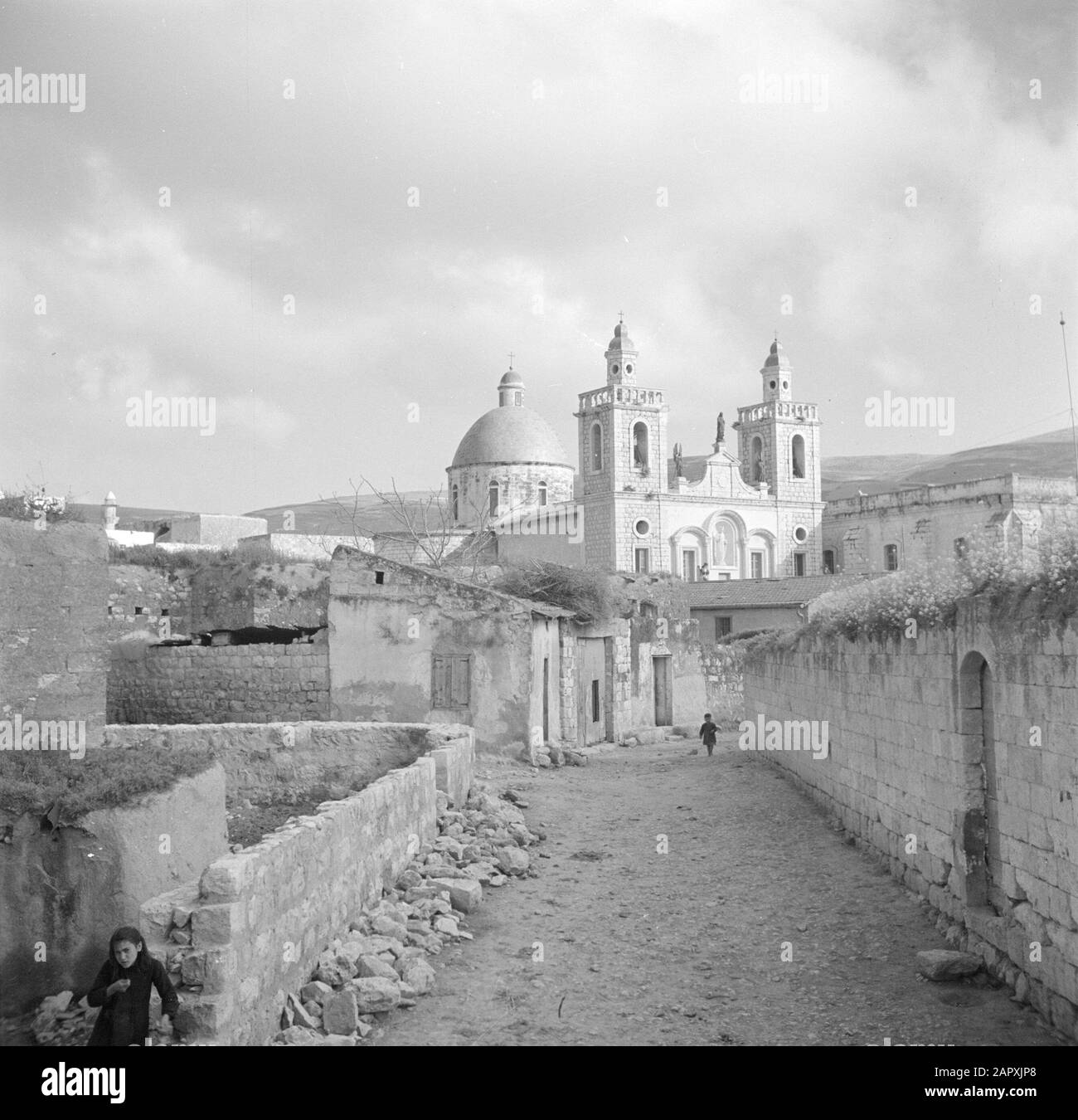 Israël 1948-1949: Rue Kana vue en direction de l'église catholique romaine de mariage Annotation: Le terme Église de mariage se réfère au miracle que Jésus de Nazareth aurait fait, où il pendant le mariage de l'eau Kana transformé en vin Date: 1948 lieu: Israël, Kana mots clés: images de village, bâtiments d'église, rues, tours Banque D'Images