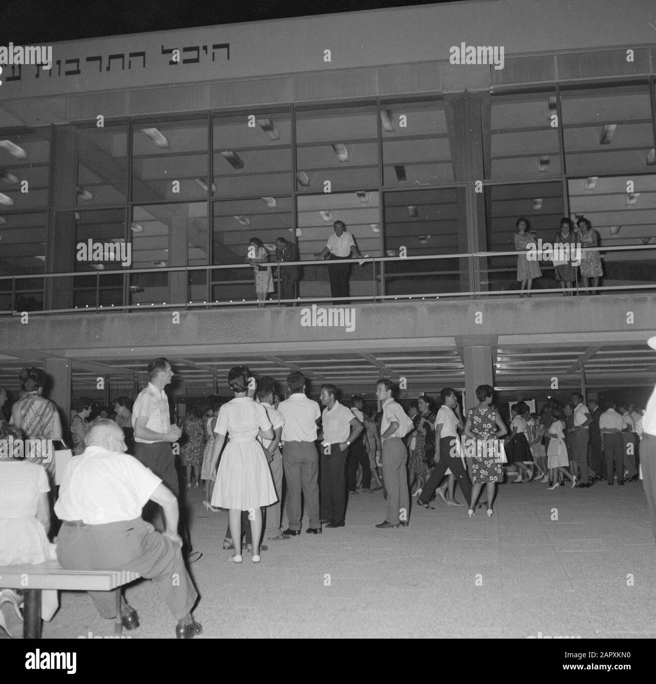 Tel Aviv. Frédéric R. Mann Auditorium vu la nuit du parking devant le bâtiment avec des rangées en attente à l'entrée Date: 1 janvier 1964 lieu: Israël, tel Aviv mots clés: Architecture, prises de vue de nuit, public, fenêtres, théâtres Nom personnel: Mann, Frederic R. Banque D'Images