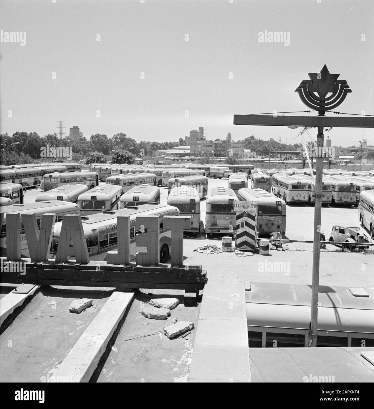Israël 1964-1965: Tel Aviv, sabbat tel Aviv le sabbat: Bus dans le parking du dépôt. A l'arrière-plan un bâtiment de la Trans World Airlines (TWA). Au premier plan de grandes lettres sur une façade (tel Aviv) Date: 1964 lieu: Israël, tel Aviv mots clés: Autobus, bâtiments, façades, religion juive, places de stationnement, scooters, statues de rue, épaves Banque D'Images