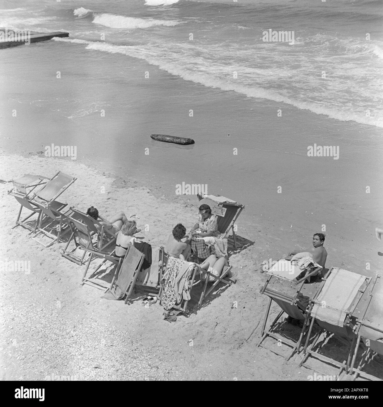 Israël 1948-1949: Tel Aviv Tel Aviv. Plage à la promenade de la plage le matin du sabbat avec chaises de plage, bains de soleil et une manucure au travail Date: 1948 lieu: Israël, Méditerranée, tel Aviv mots clés: Religion juive, manucure, public, plages, chaises de plage, mer Banque D'Images