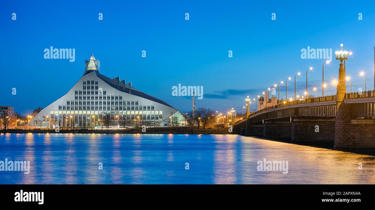 Pont au-dessus de la rivière Duena avec bibliothèque nationale au crépuscule, Riga, Lettonie Banque D'Images