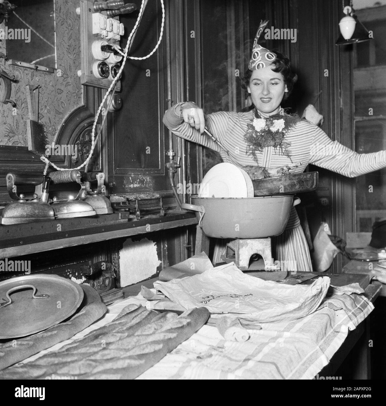 Fête de Sainte Cathérine à Paris, les vacances des maisons de mode françaises le 25 novembre Entre les boulons à repasser Colette montre sa dernière création: Un "gigot de malouton" (sheepbout) Annotation: À Paris est célébrée la fête de Sainte Cathédrale par des filles qui sont encore non mariées à l'âge de 25 ans, travaillant dans l'industrie de la mode. Sainte Cathédrale est leur condescendance Date: {1950-1955} lieu: France, Paris mots clés: Vacances, fêtes, repas, maisons de mode Banque D'Images