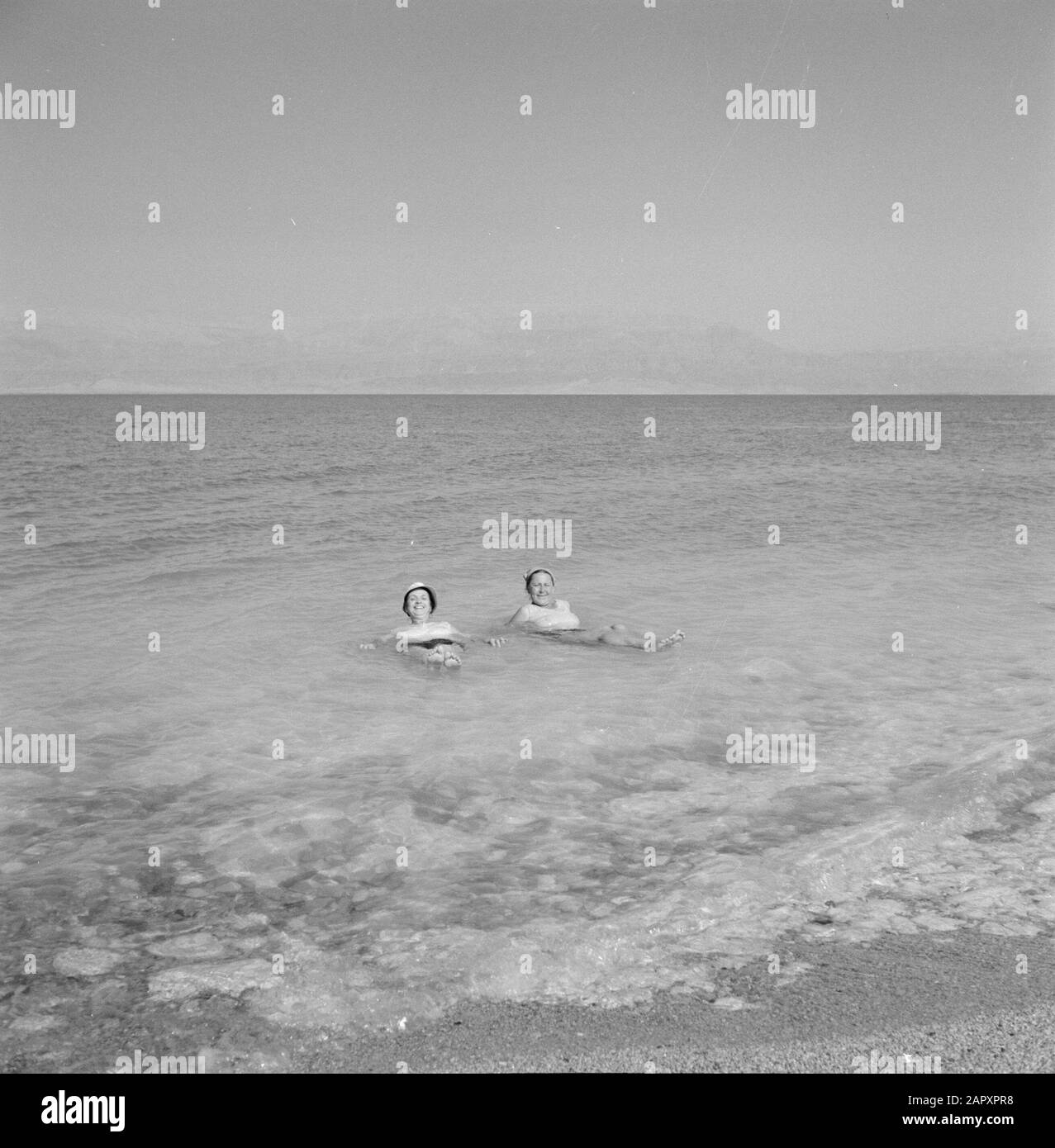 Israël 1964-1965: La mer morte, Sodome Deux femmes flottent dans la mer Morte. Annotation : la mer Morte n'est pas seulement la plus salée mais aussi la plus grande eau minérale au monde. Il y a une concentration exceptionnellement élevée de potassium, de brome, de magnésium et d'iode. Date: 1964 lieu: Mer morte, Israël, Sodome mots clés: Baigneurs, mers, sel Banque D'Images