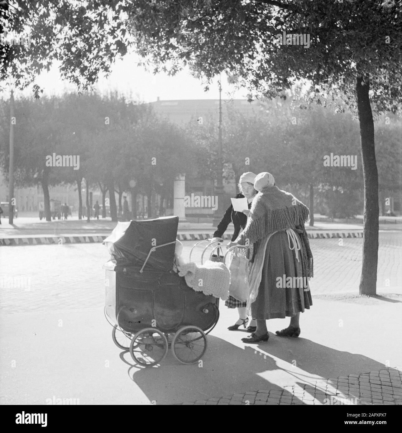 Rome: Visite de la ville Deux femmes avec poussettes faisant un chat au soleil sur la rue Date: 1937 lieu: Italie, Rome mots clés: Baby-sitter, poussettes, parcs, statues de rue, femmes. Ensoleillé Banque D'Images