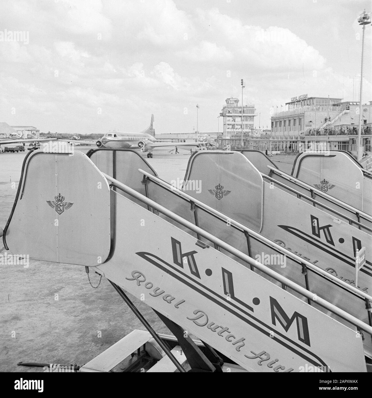 Schiphol et identité de l'entreprise KLM Quatre escaliers de vol KLM sur la zone d'ajustement de l'avion à l'aéroport de Schiphol. En arrière-plan, la tour de contrôle et la terrasse du café de Wide blik tandis qu'un taxi KLM Convair 240. Date : août 1951 lieu : Noord-Holland, Oud-Schiphol mots clés : cafés, tours de circulation, avions, escaliers de vol, aéroports Banque D'Images