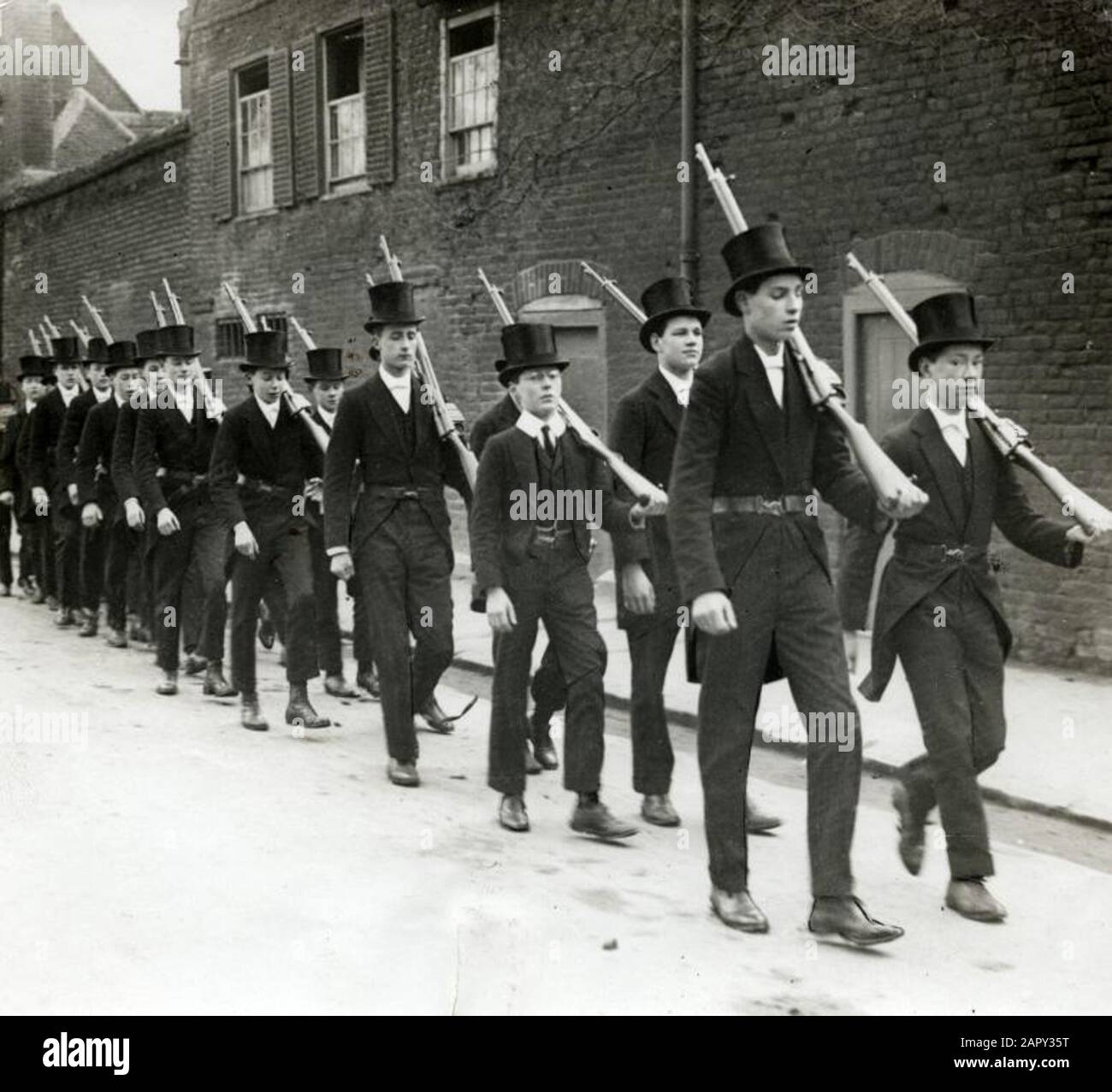 Première Guerre mondiale: Mobilisation, déclaration de guerre: Garçons de l'université d'Eton pendant l'exercice, avec des costumes et des chapeaux hauts sur et fusil sur leurs épaules. Angleterre, 1915. Banque D'Images